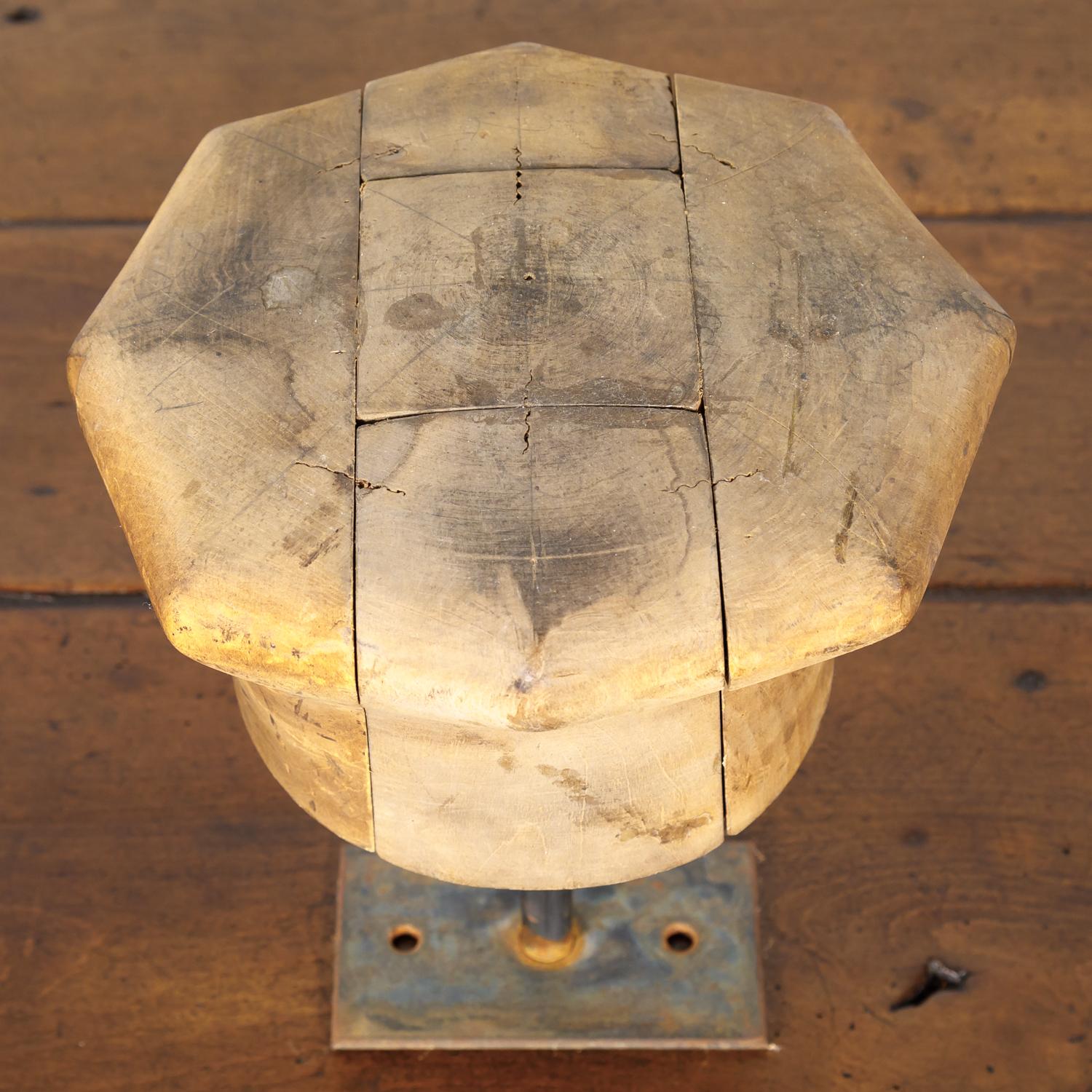 A wonderful set of three wooden French hat molds or blocks once used by a milliner to shape his or her hats, circa 1900. Each mold is mounted on an oxidized steel base and is unique, having a different size, shape, and patina. These old milliners'