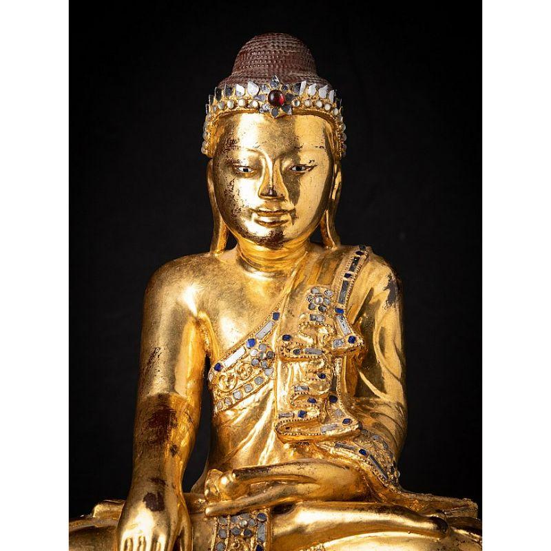 Material: wood
52,5 cm high 
36 cm wide and 24 cm deep
Weight: 6.35 kgs
Gilded with 24 krt. gold
Mandalay style
Bhumisparsha mudra
Originating from Burma
19th century
With inlayed eyes.

