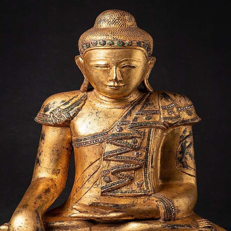 Material: wood
63,5 cm high 
48 cm wide and 33,5 cm deep
Weight: 17.85 kgs
Gilded with 24 krt. gold
Mandalay style
Bhumisparsha mudra
Originating from Burma
Early 20th century.
 