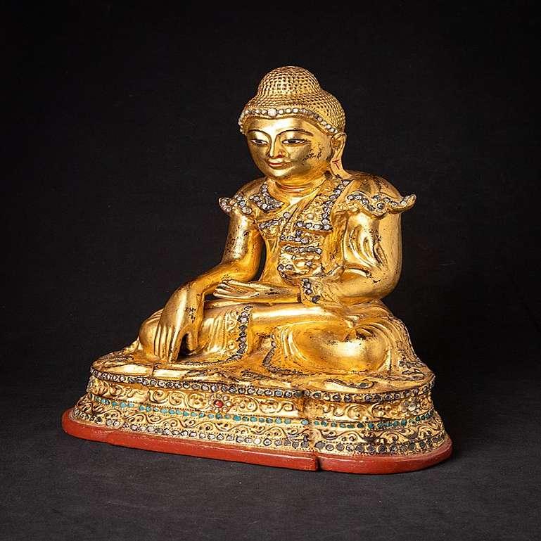 Material: wood
38 cm high 
32 cm wide and 23 cm deep
Weight: 4.077 kgs
Gilded with 24 krt. gold
Mandalay style
Bhumisparsha mudra
Originating from Burma
Late 19th / early 20th century
With Burmese inscriptions on the backside, probably the