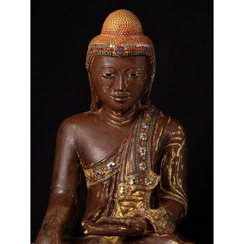 Material: wood
49,7 cm high 
44 cm wide and 31 cm deep
Weight: 9.75 kgs
Gilded with 24 krt. gold
Mandalay style
Bhumisparsha mudra
Originating from Burma
19th century
With inlayed eyes

