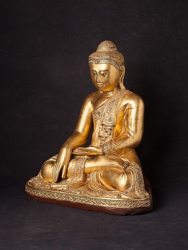 Material: wood
47,2 cm high 
42,2 cm wide and 27,7 cm deep
Weight: 7.6 kgs
Gilded with 24 krt. gold
Mandalay style
Bhumisparsha mudra
Originating from Burma
19th century
With inlayed eyes
A beautiful piece !.
 