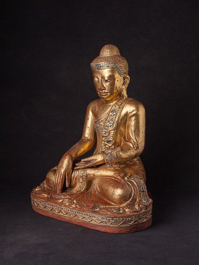 Material: wood
44,5 cm high 
34,6 cm wide and 24,8 cm deep
Weight: 5.9 kgs
Gilded with 24 krt. gold
Mandalay style
Bhumisparsha mudra
Originating from Burma
19th century
With inlayed eyes.
 