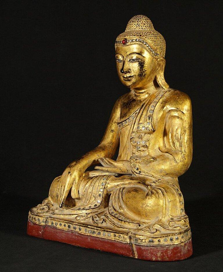 This antique wooden Buddha statue is a truly unique and special collectible piece. Standing at 39 cm high, 32 cm wide and 21 cm deep, it is made of wood, and it is gilded with 24 krt gold. The intricate details on the statue are inlaid with