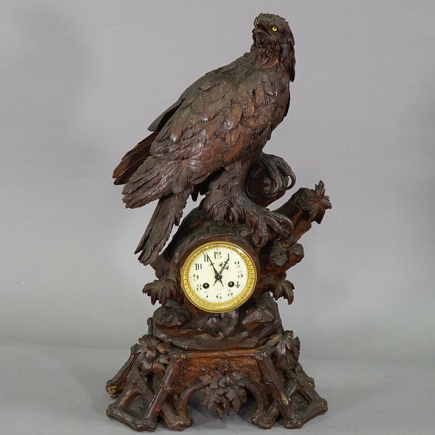 Pendule de cheminée ancienne en bois avec aigle, Suisse, 1900

Une superbe horloge de cheminée en bois de tilleul sculpté avec un aigle sculpté très détaillé assis sur un rocher avec des décorations de feuillage. Le cadran en porcelaine a des