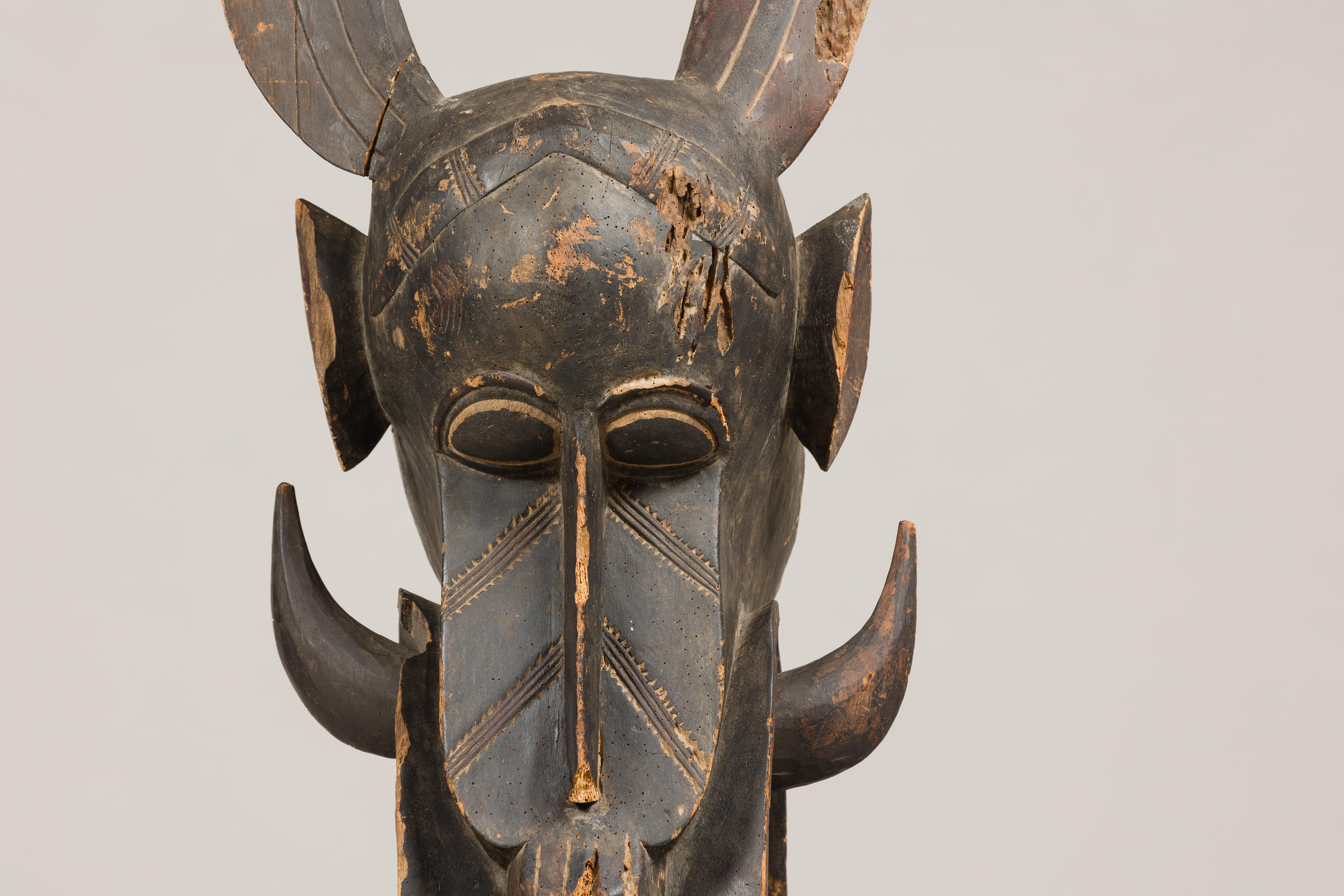 Masque mythique animal en bois ancien monté sur une base en laque noire en vente 3