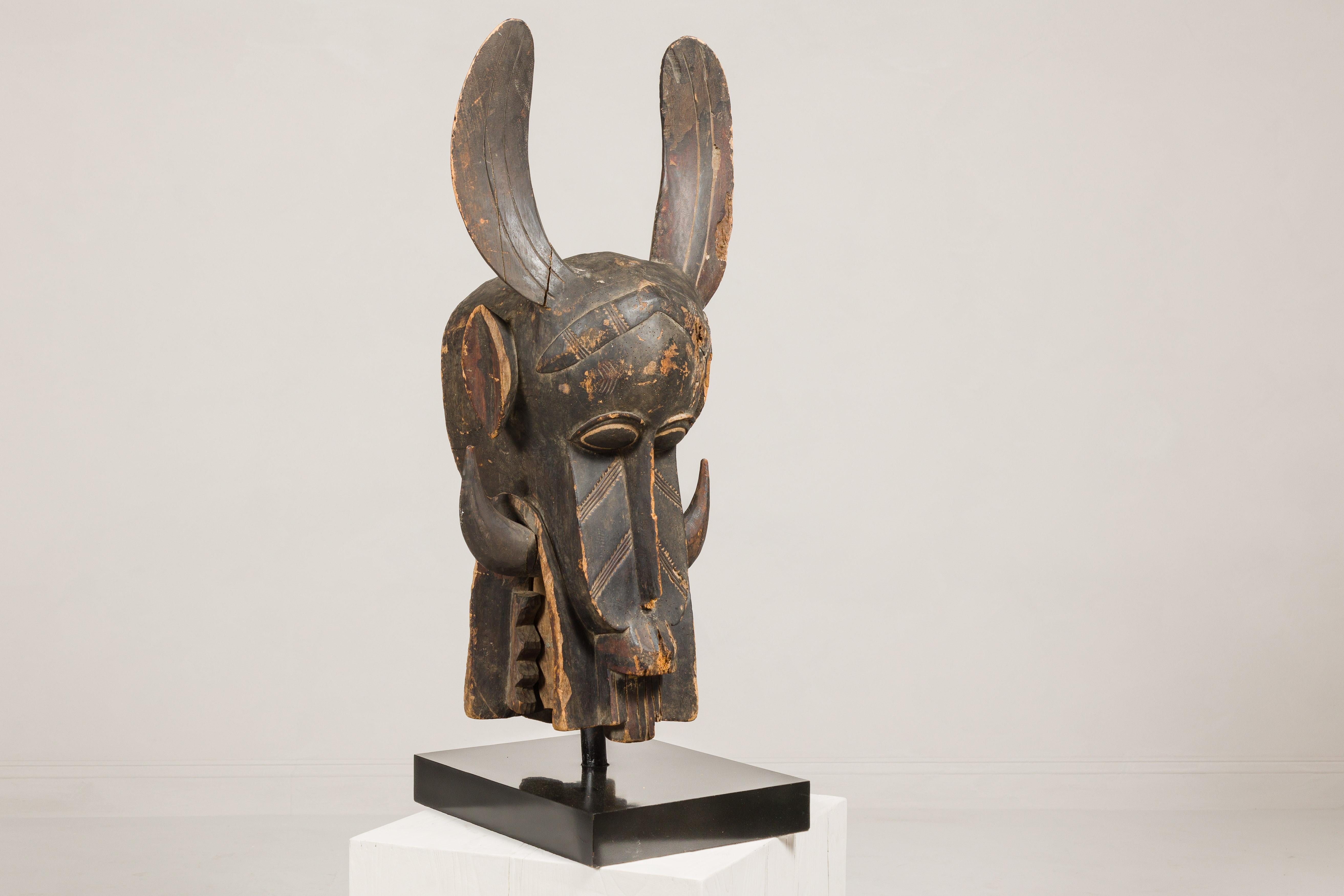 Masque mythique animal en bois ancien monté sur une base en laque noire en vente 4