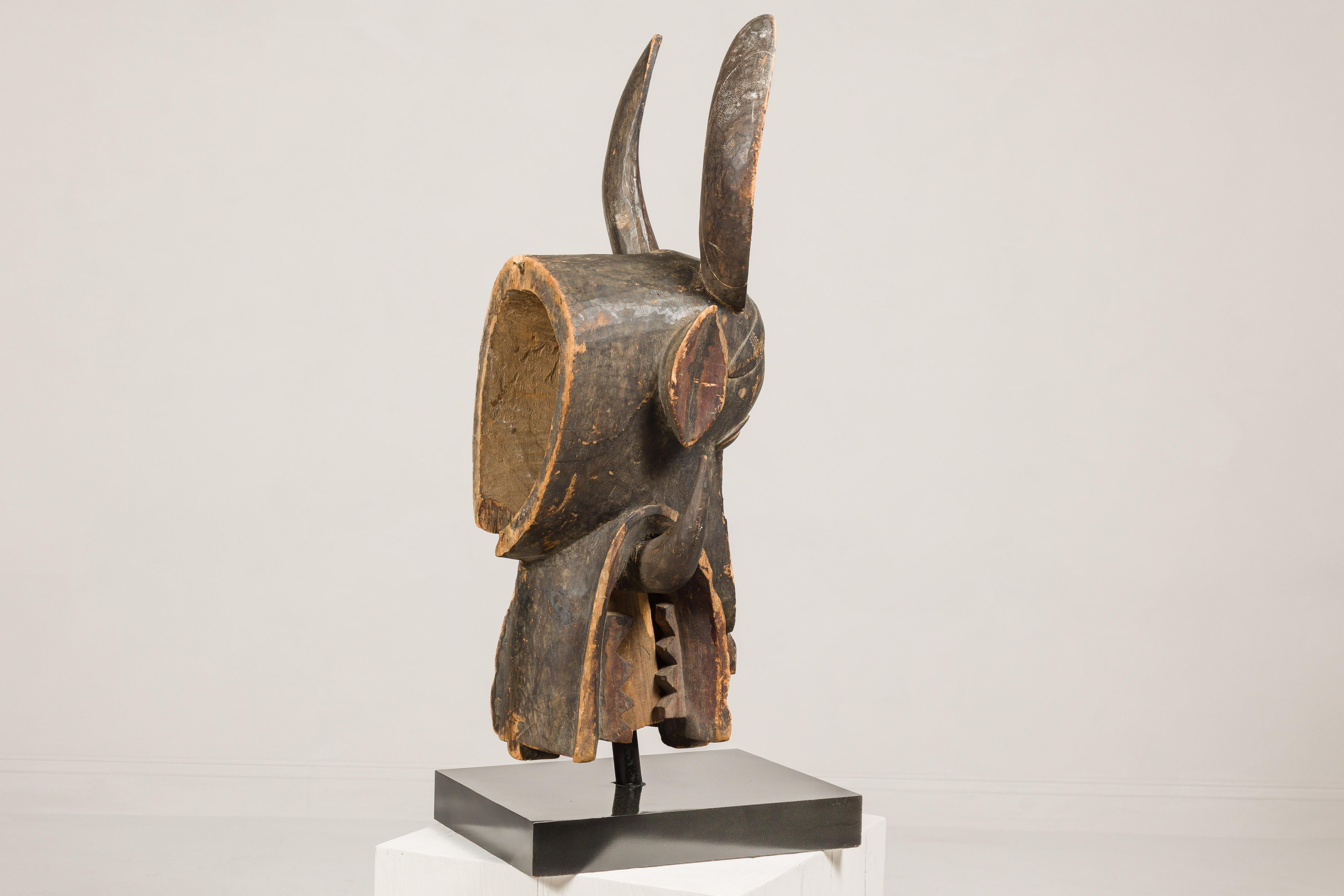 Masque mythique animal en bois ancien monté sur une base en laque noire en vente 7