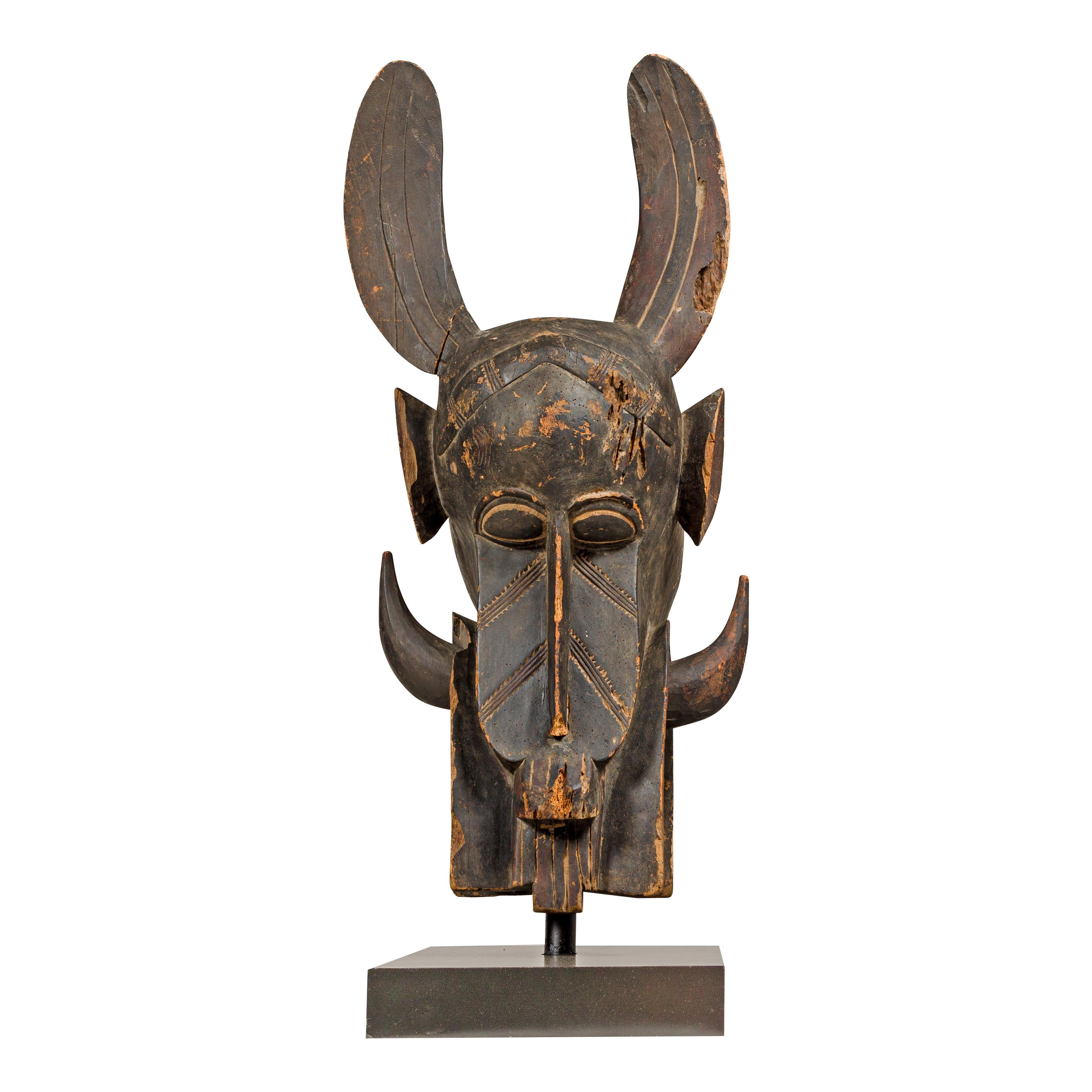Masque mythique animal en bois ancien monté sur une base en laque noire en vente 12
