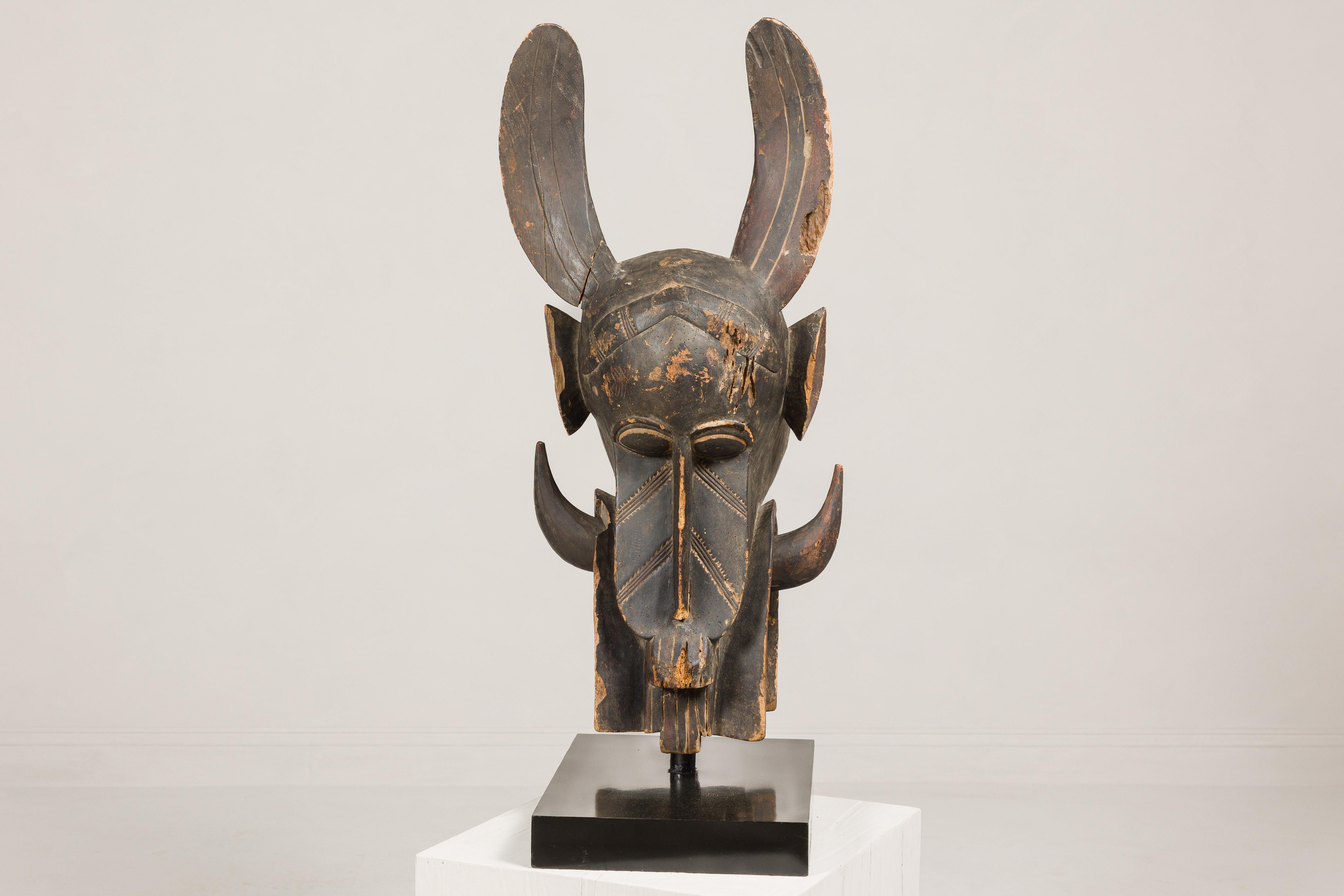 Primitif Masque mythique animal en bois ancien monté sur une base en laque noire en vente