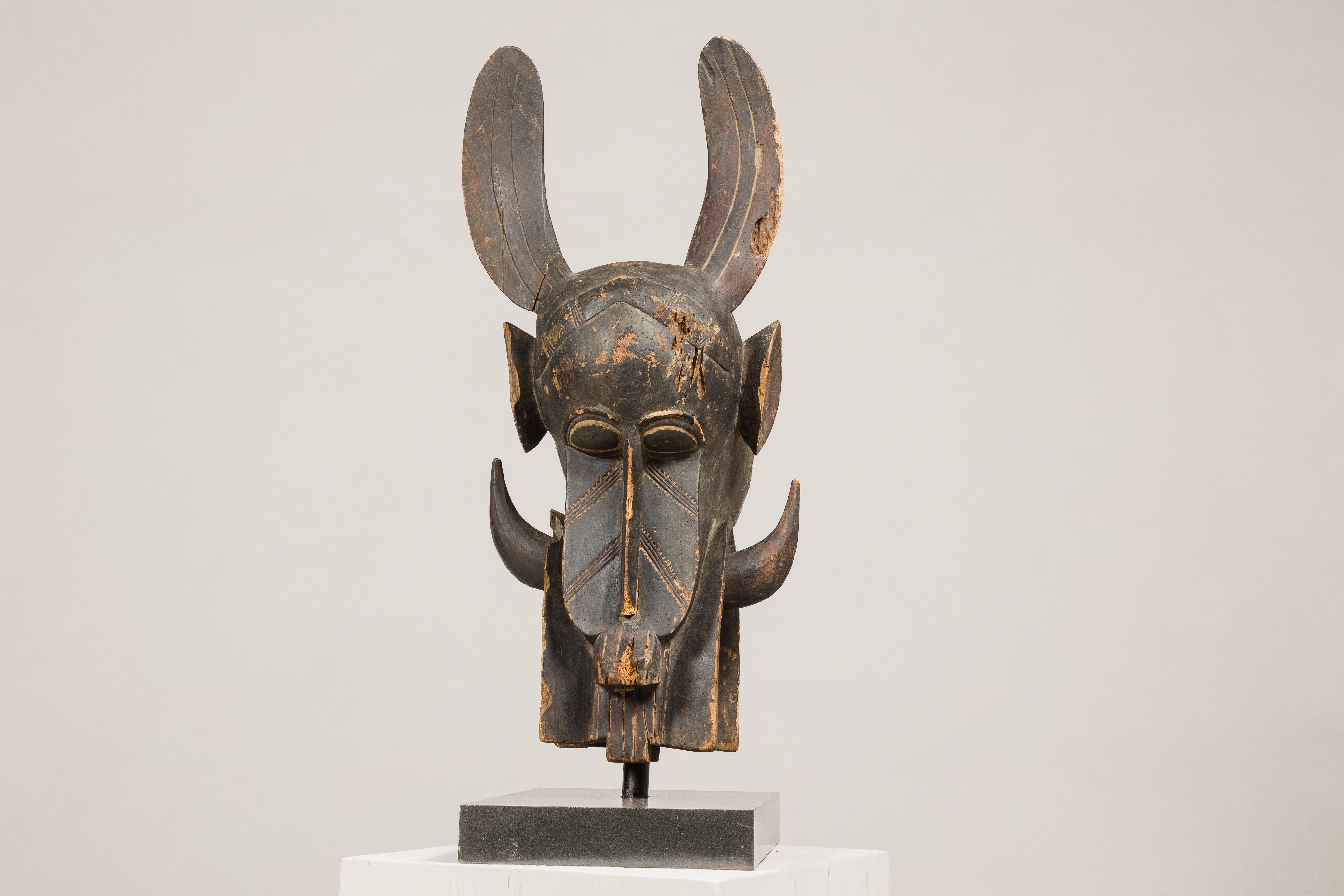 Masque mythique animal en bois ancien monté sur une base en laque noire en vente 1