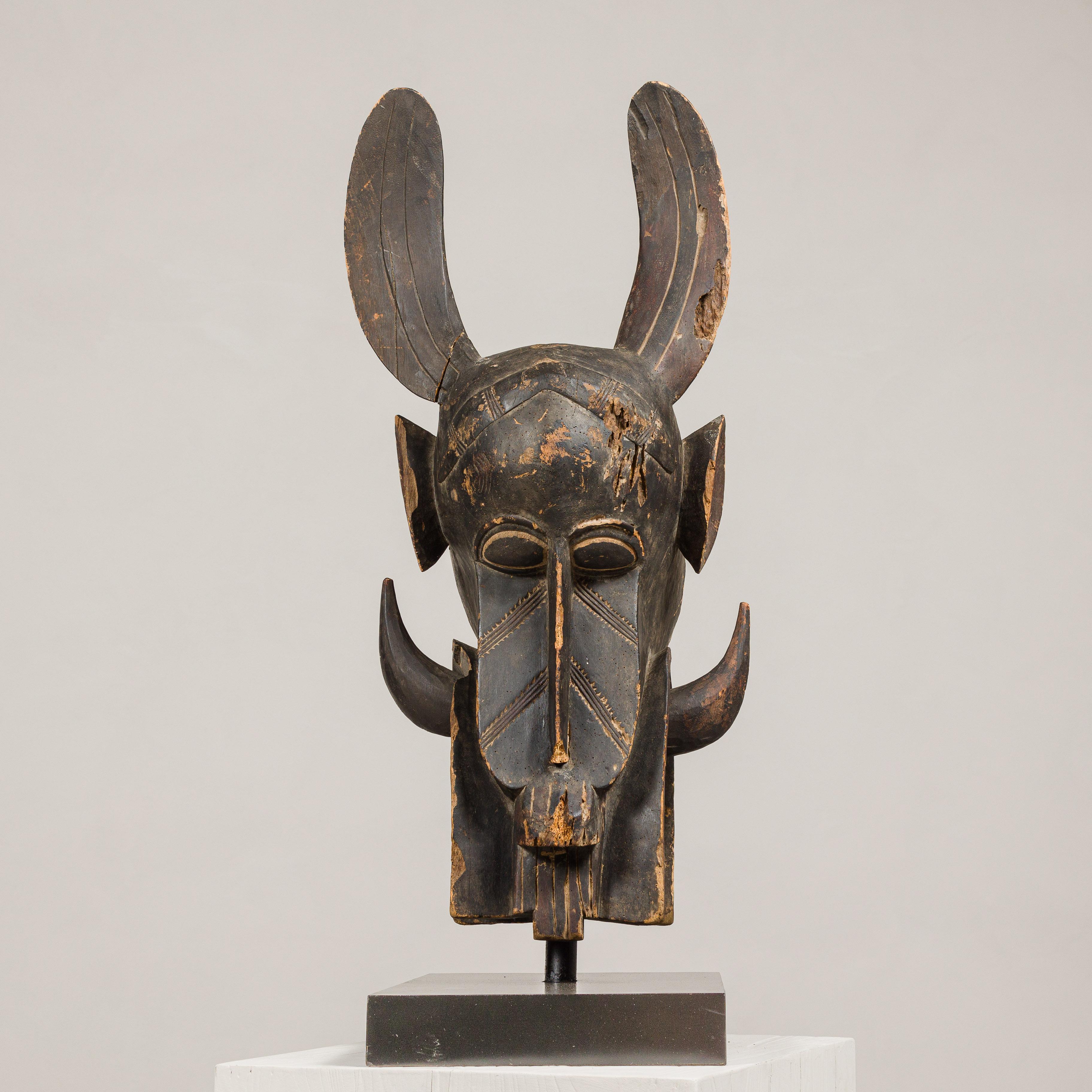 Masque mythique animal en bois ancien monté sur une base en laque noire en vente 2