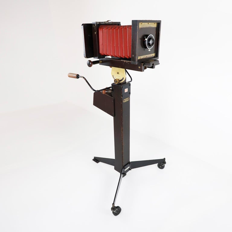 Circa 1960. We offer this antique wooden plate folding photographic camera with stand, the camera still working.