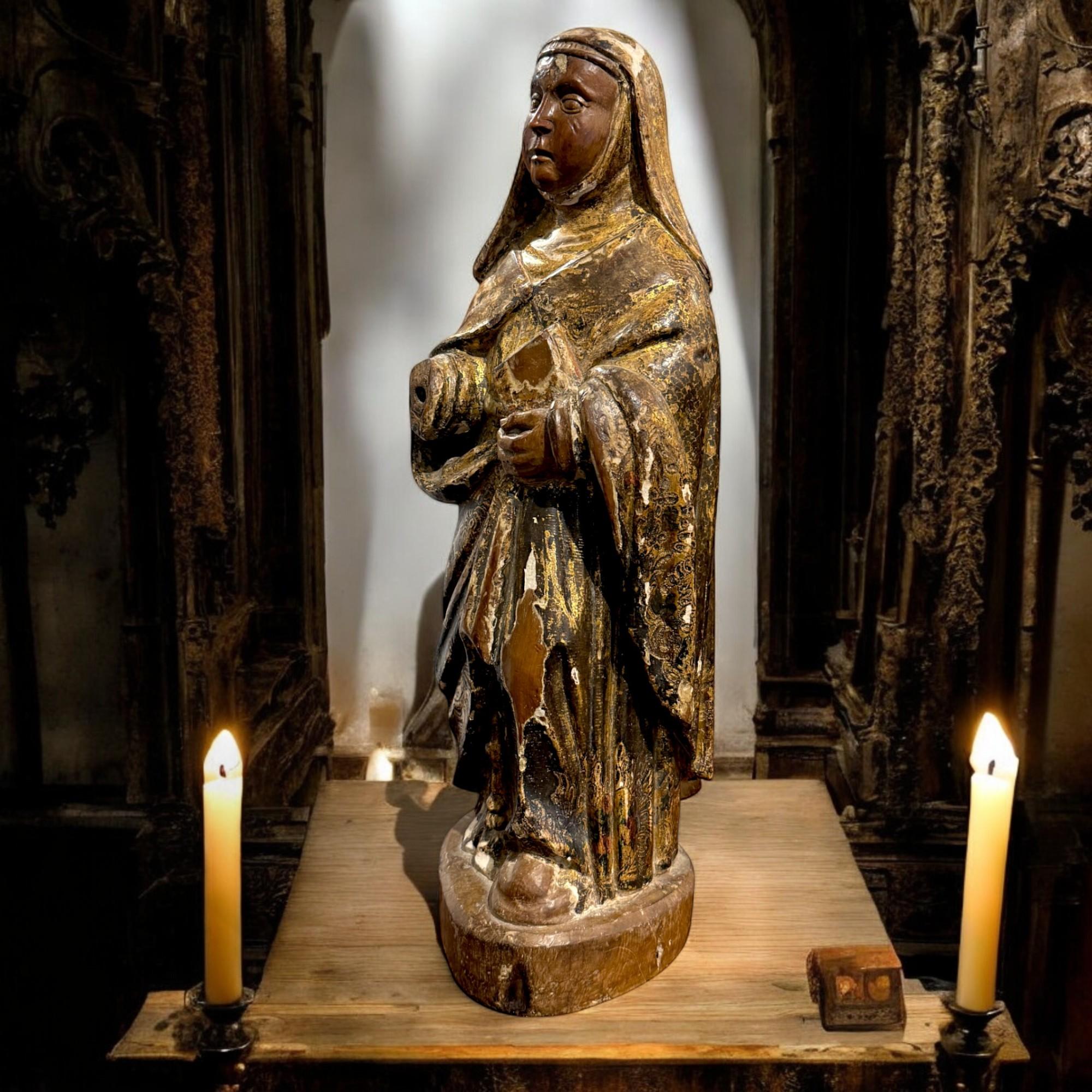 Sculpture évocatrice en bois du XVIIe siècle représentant une sainte, finement sculptée et ornée de vestiges de la polychromie et de la dorure d'origine. Son expression sereine et sa posture gracieuse traduisent une force tranquille et une dévotion