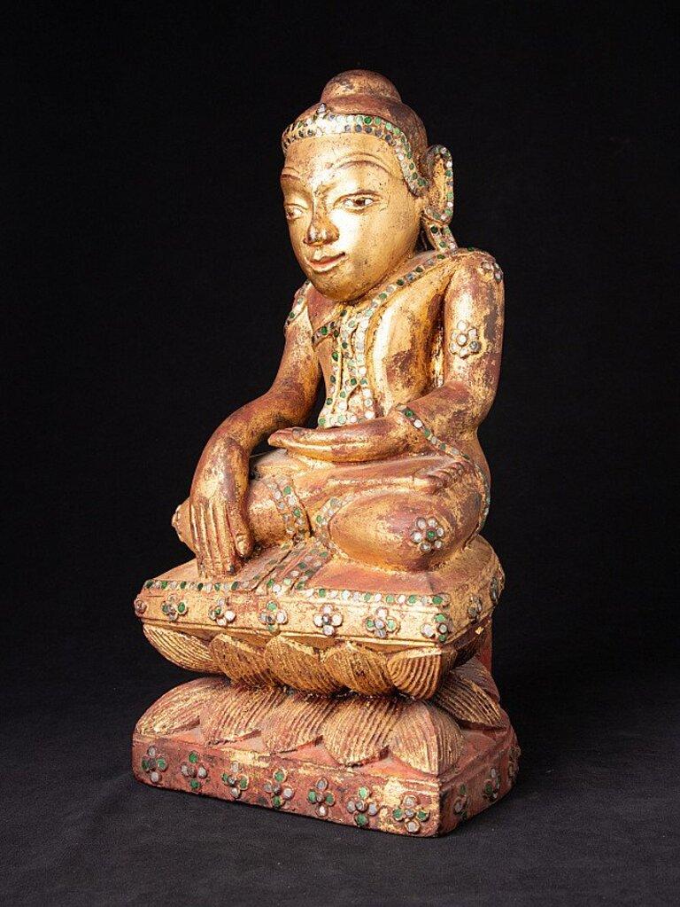 Material: wood
42 cm high 
22,3 cm wide and 16,5 cm deep
Weight: 3.554 kgs
Gilded with 24 krt. gold
Shan (Tai Yai) style
Bhumisparsha mudra
Originating from Burma
18th century.
 