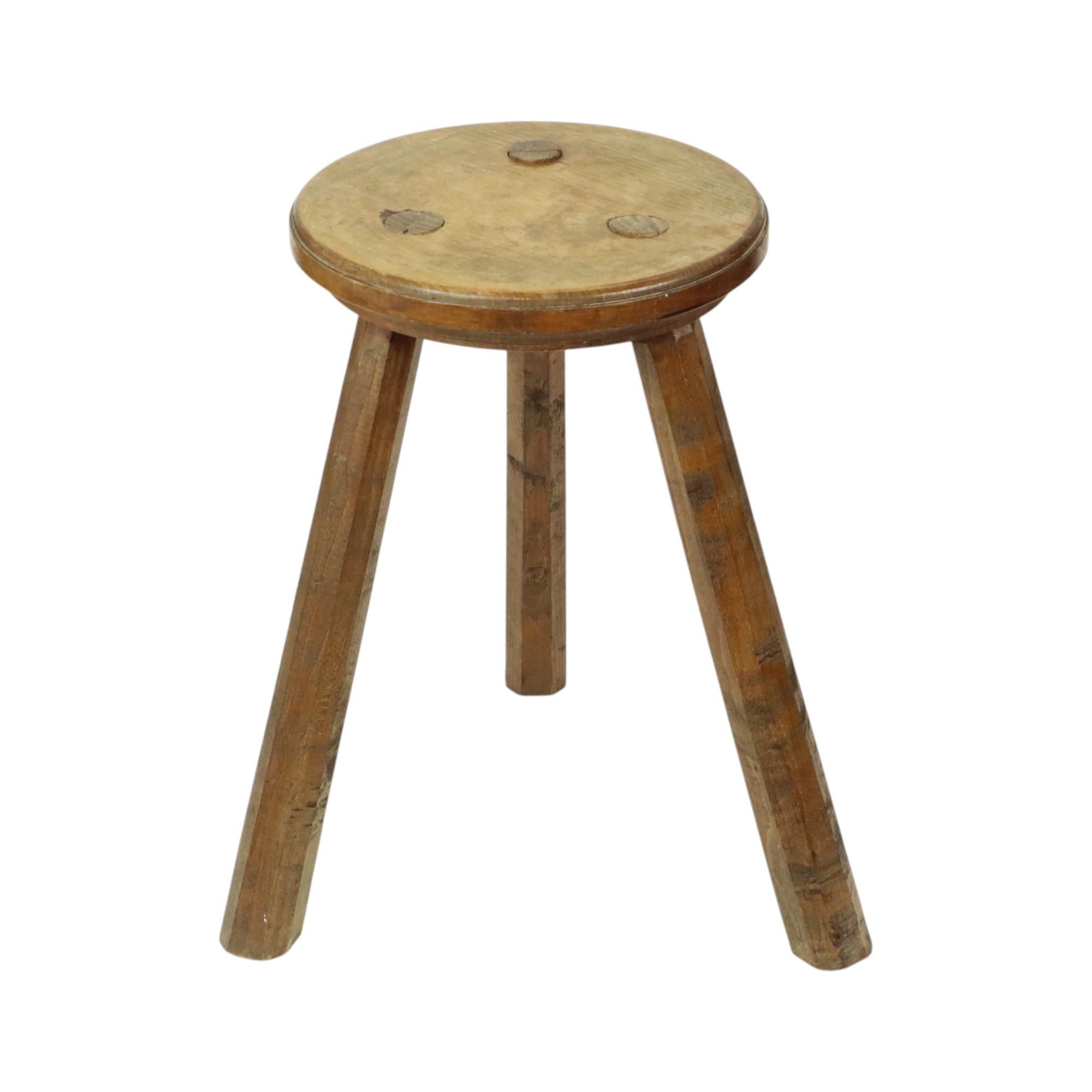 Ein schöner antiker Dreibeinhocker aus Holz, ein Milchhocker. Dies ist eine rustikale und brutalistische handgefertigte Antiquität aus dem frühen 20. Jahrhundert. Es ist auch ein schöner Pflanzenständer.

Dreibeinhocker wurden in der Vergangenheit