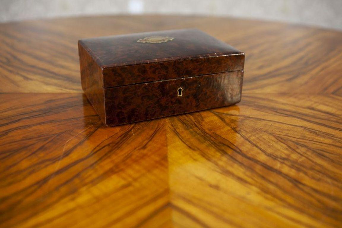 Antique Wooden Vanity Box From the Early 20th Century

A small-sized vanity box veneered with walnut burl. It features a lid with a gently rounded shape and central inlay. The interior is lined with velvet fabric, and inside the lid, there is a