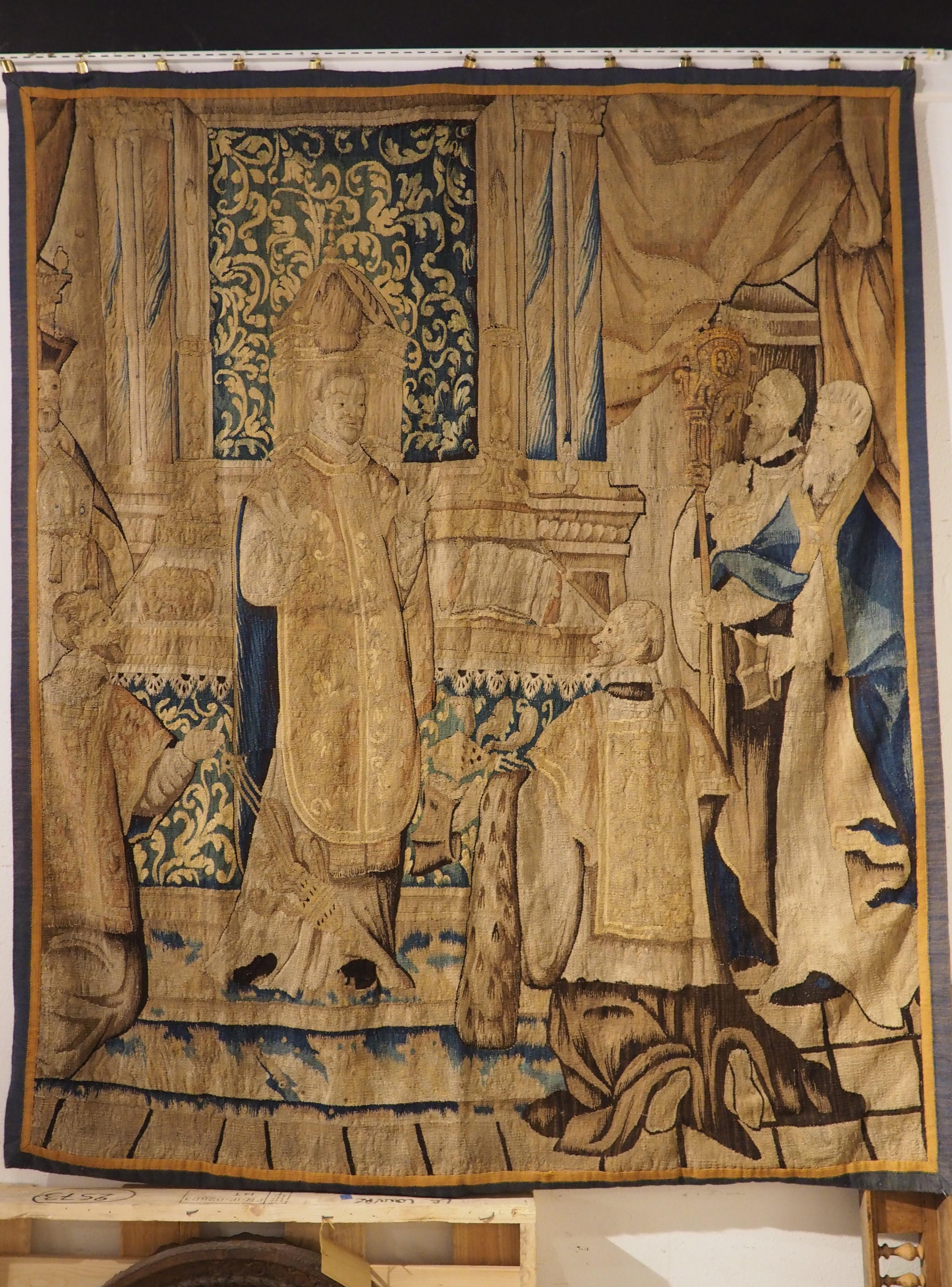 Hand-woven in Brussels, circa 1650, this wool and silk tapestry depicts a church scene with six clergymen at an altar. After roughly 375 years, the colors are still vibrant, highlighted by fabrics of blue that punctuate the predominately gold,