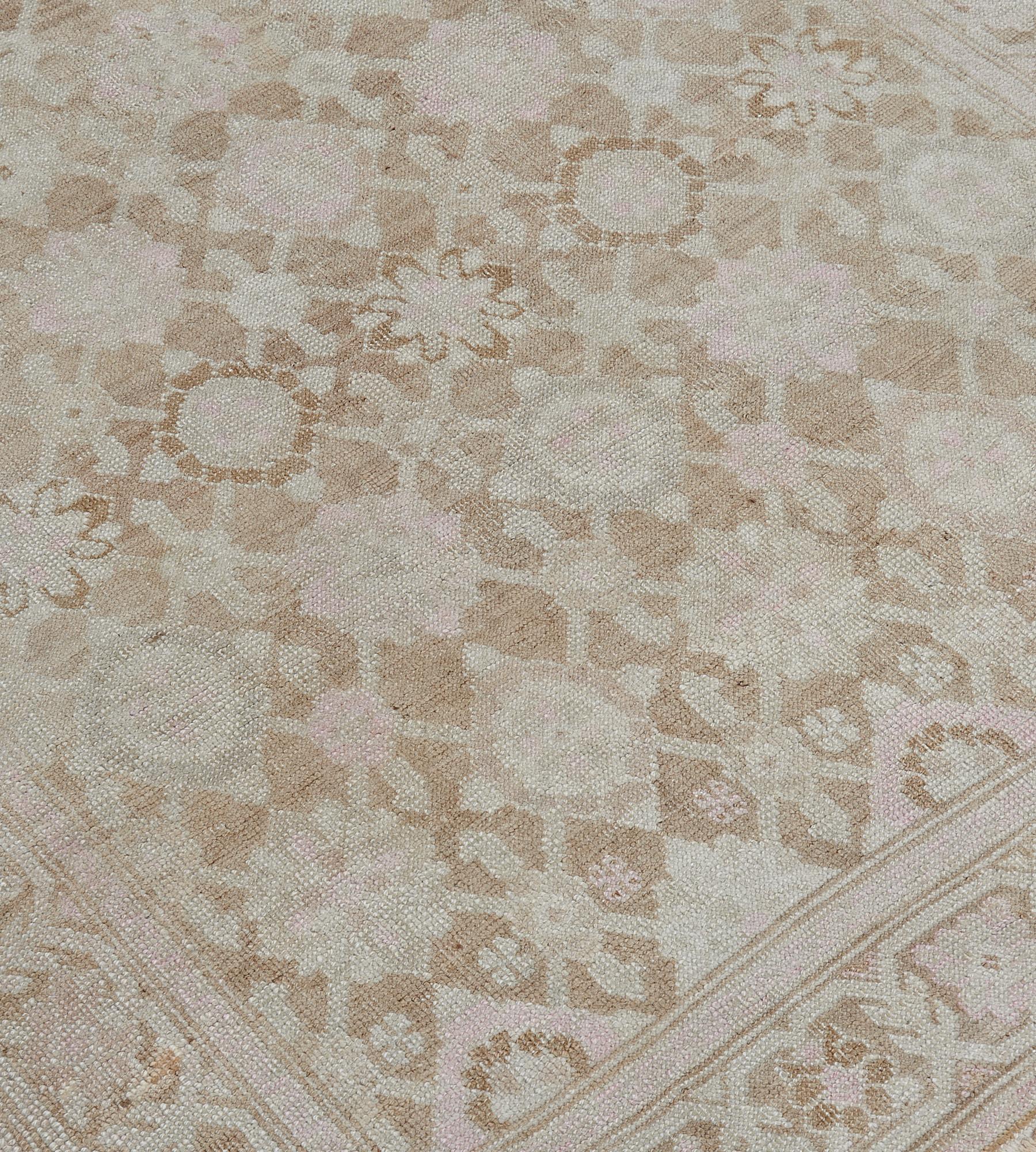 This antique Karabagh runner has a buff-brown field with an overall ivory and dusty-pink bold lozenge and palmette vine, in a similar buff-brown and ivory angular palmette vine border between dusty-pink floral vine stripes, outer narrow buff-brown