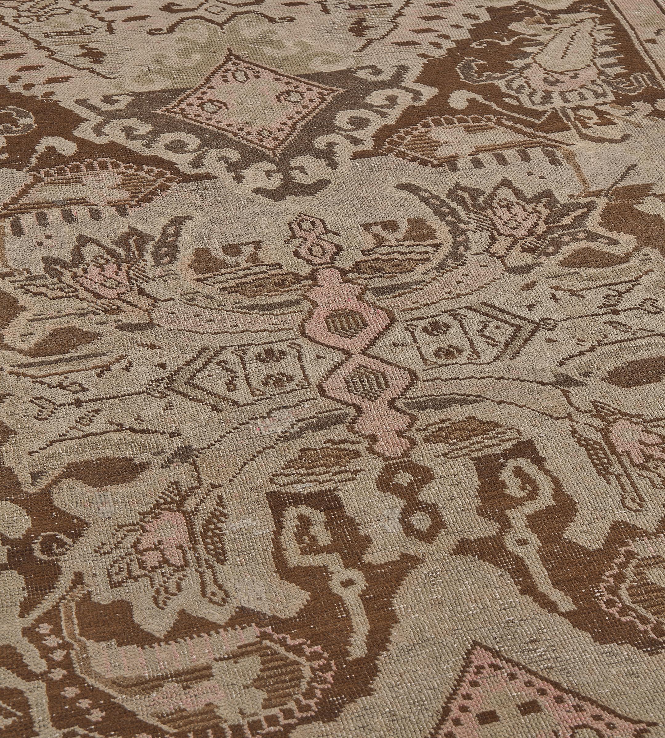 Cet antique chemin de table du Karabagh présente un champ brun chocolat nuancé avec une vigne florale en volutes brun chamois et rose poussiéreux autour d'une colonne de losanges avec des losanges mineurs au-dessus et sur les côtés reliés par des