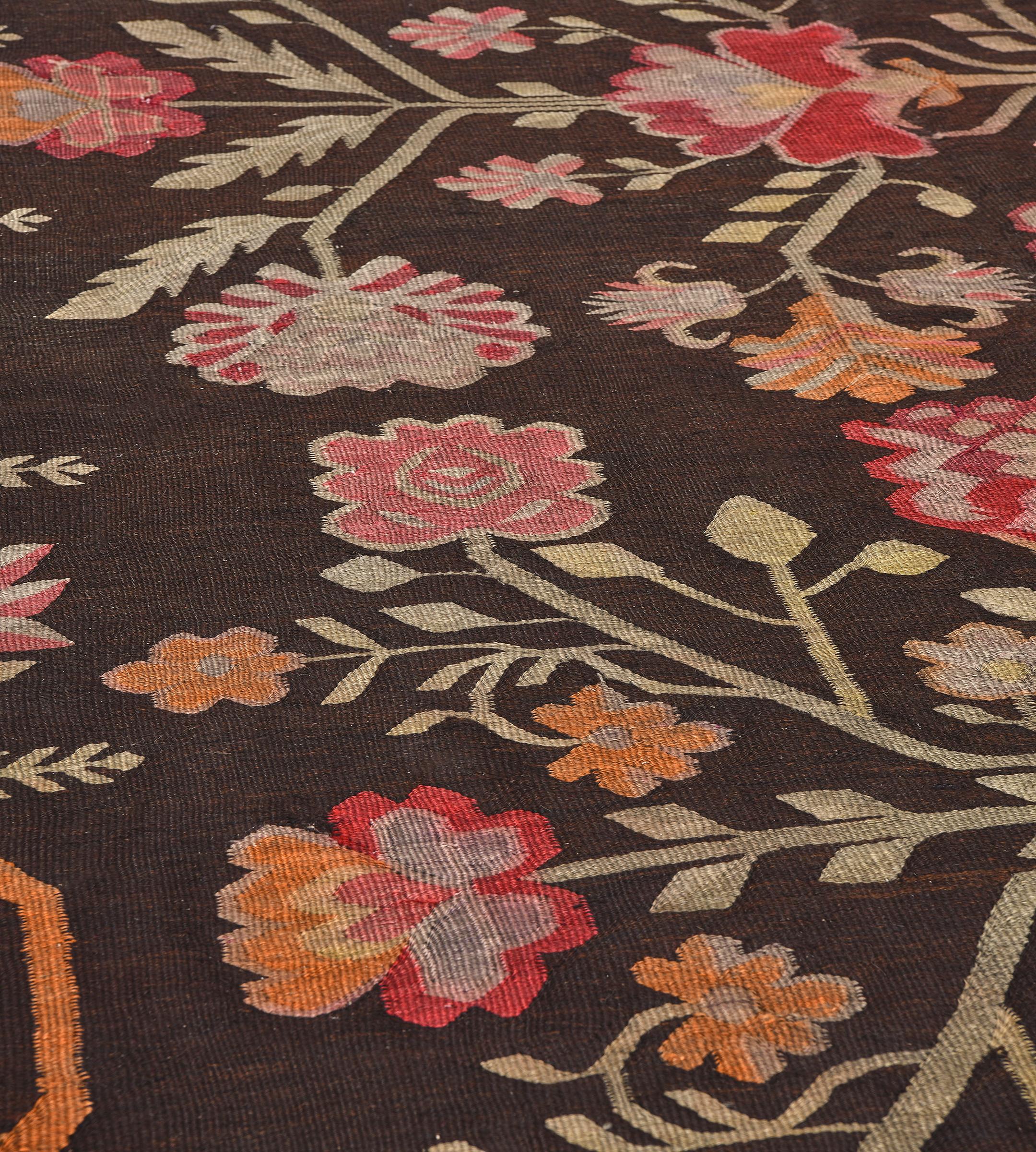 This traditional hand-woven Romanian Bessarabian rug has a shaded dark chocolate overall field with four elegant tonal floral vases radiating angled rosettes and delicate leaves, in a complementary refined scrolling floral vine.