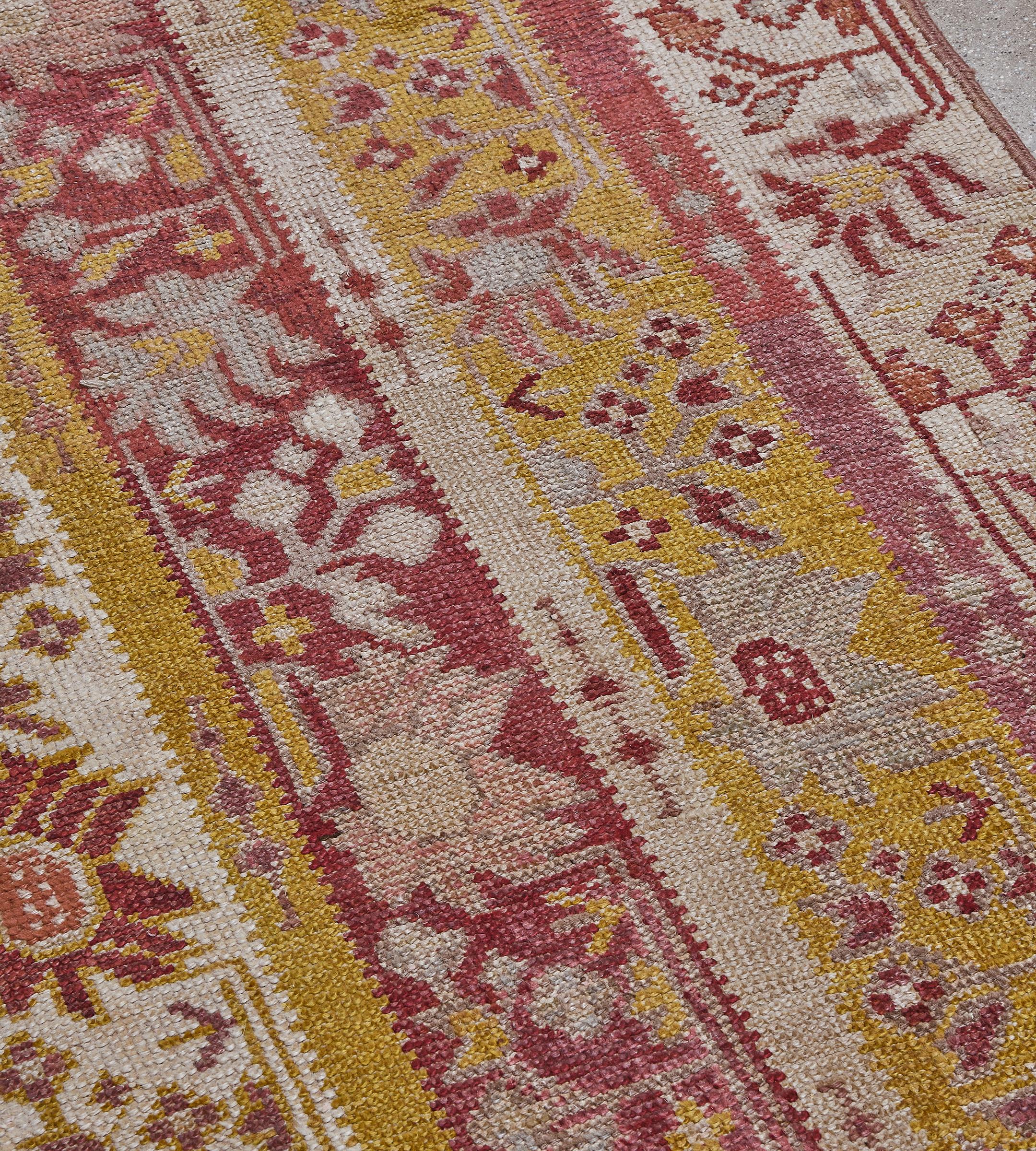 Annodato a mano Runner turco in lana antica con colonne floreali in avorio, giallo e rosso lampone in vendita