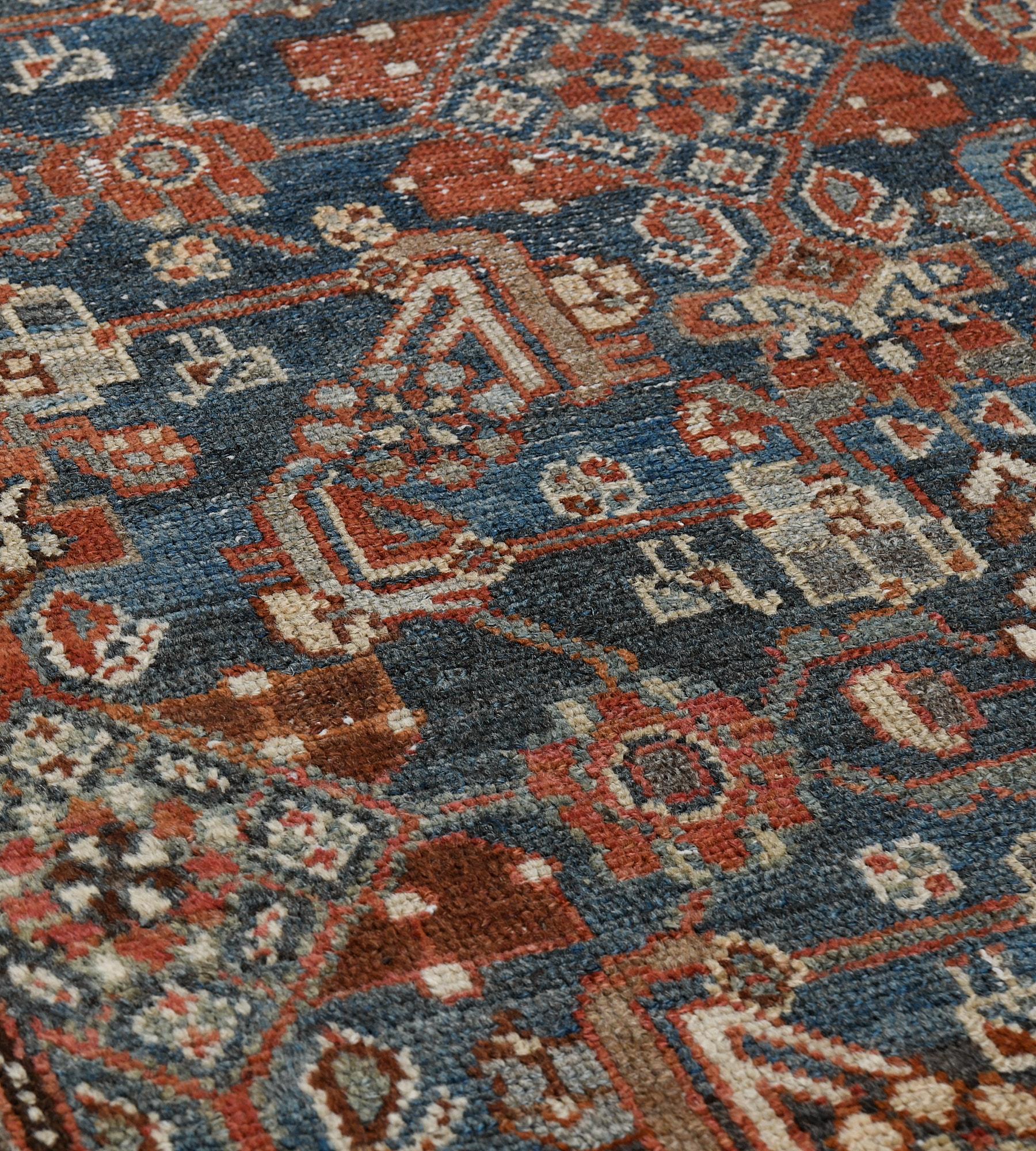 This antique Malayer rug has a shaded sea-blue field with an overall design of fox-brown, ivory, light blue and buff-brown angular palmette and floral vine, in a broad ivory border of angular rust-red and light grey floral vine between light blue