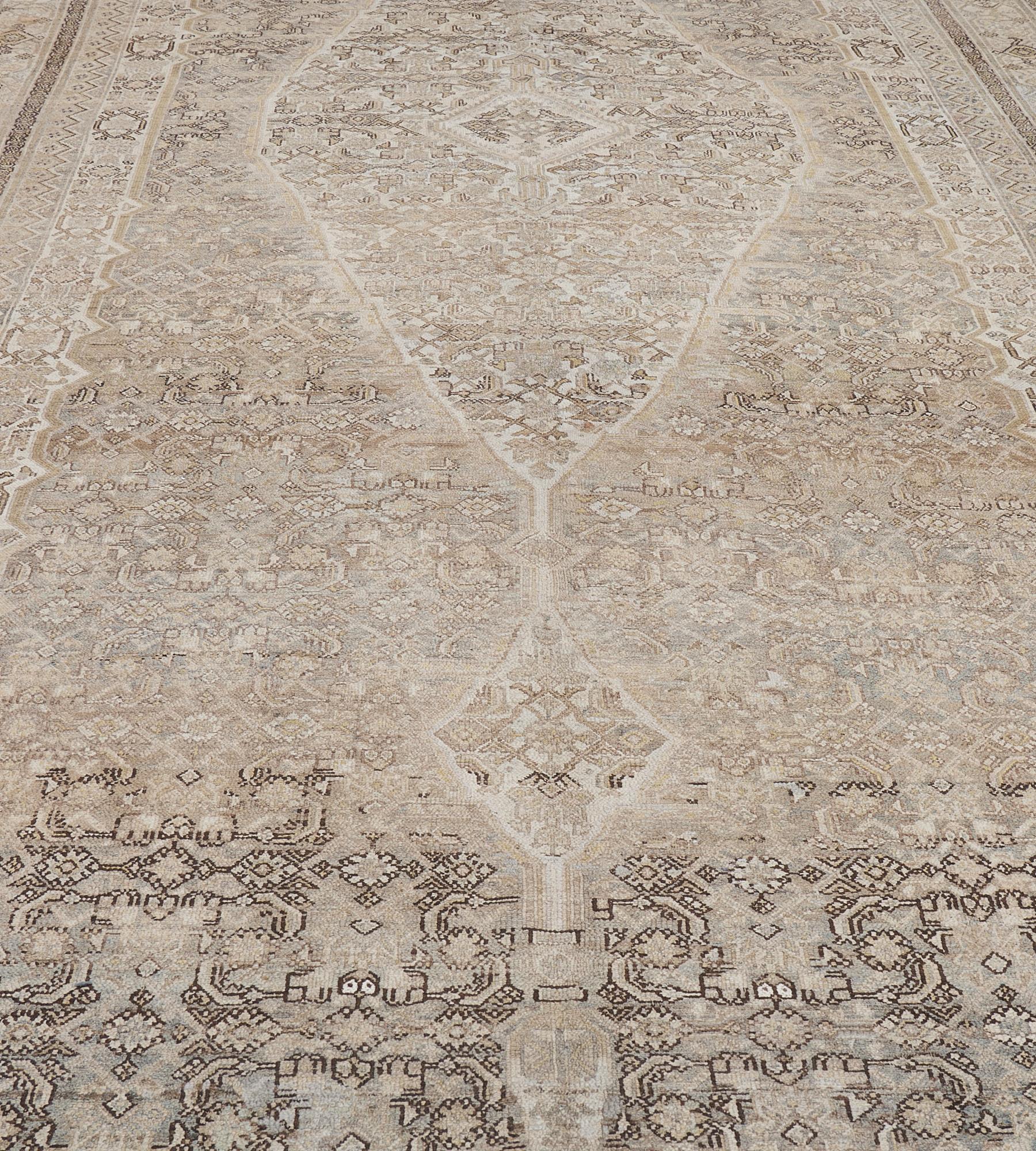 This large antique Persian Serab runner has a shaded steel-grey field with a dense angular herati-pattern around a large ivory lozenge medallion and palmette pendants containing a central lozenge surrounded by angular herati-pattern, the ivory