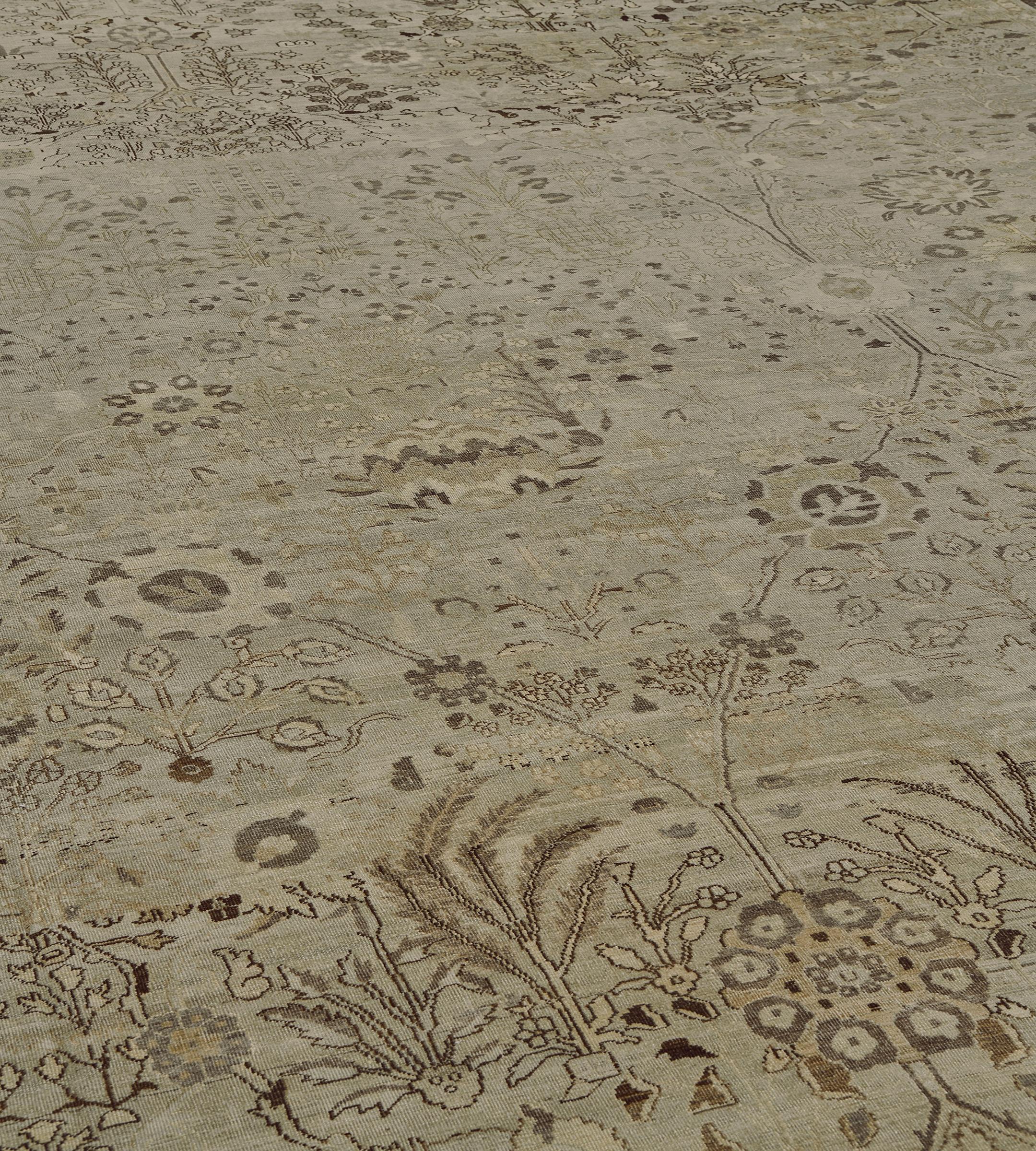 Cet ancien tapis d'Agra a un champ brun chamois avec un motif général de vases fleuris délicats brun taupe et de plantes à feuilles florales reliées par de délicates vrilles enroulées entourant des gerbes florales et des palmettes, dans une bordure