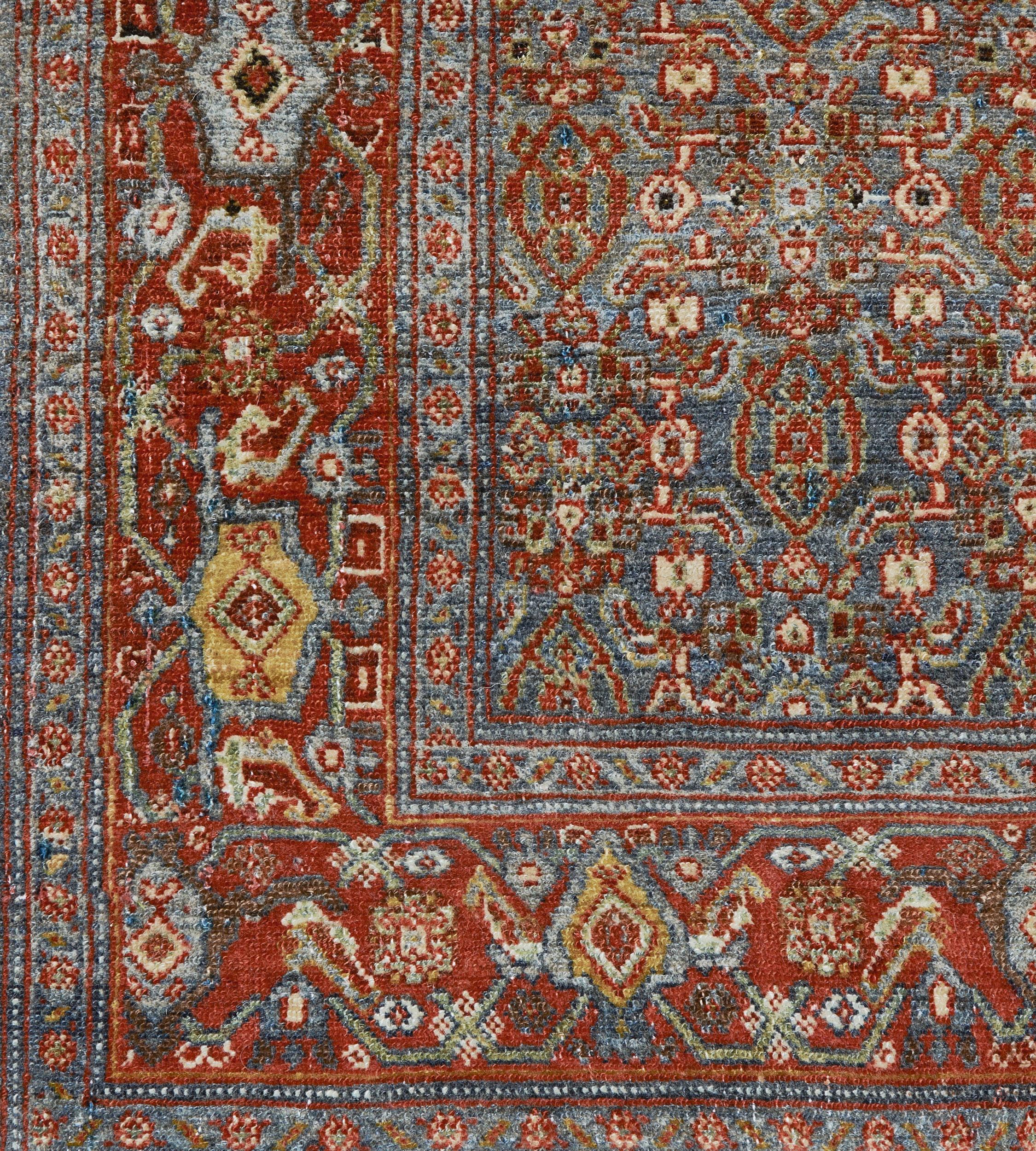 This antique Seneh runner features a shaded sea-blue field with an overall brick-red, light green and ivory herati-pattern, in tomato-red border of polychrome turtle-palmettes linked by angular floral and leafy vine between light blue floral vine