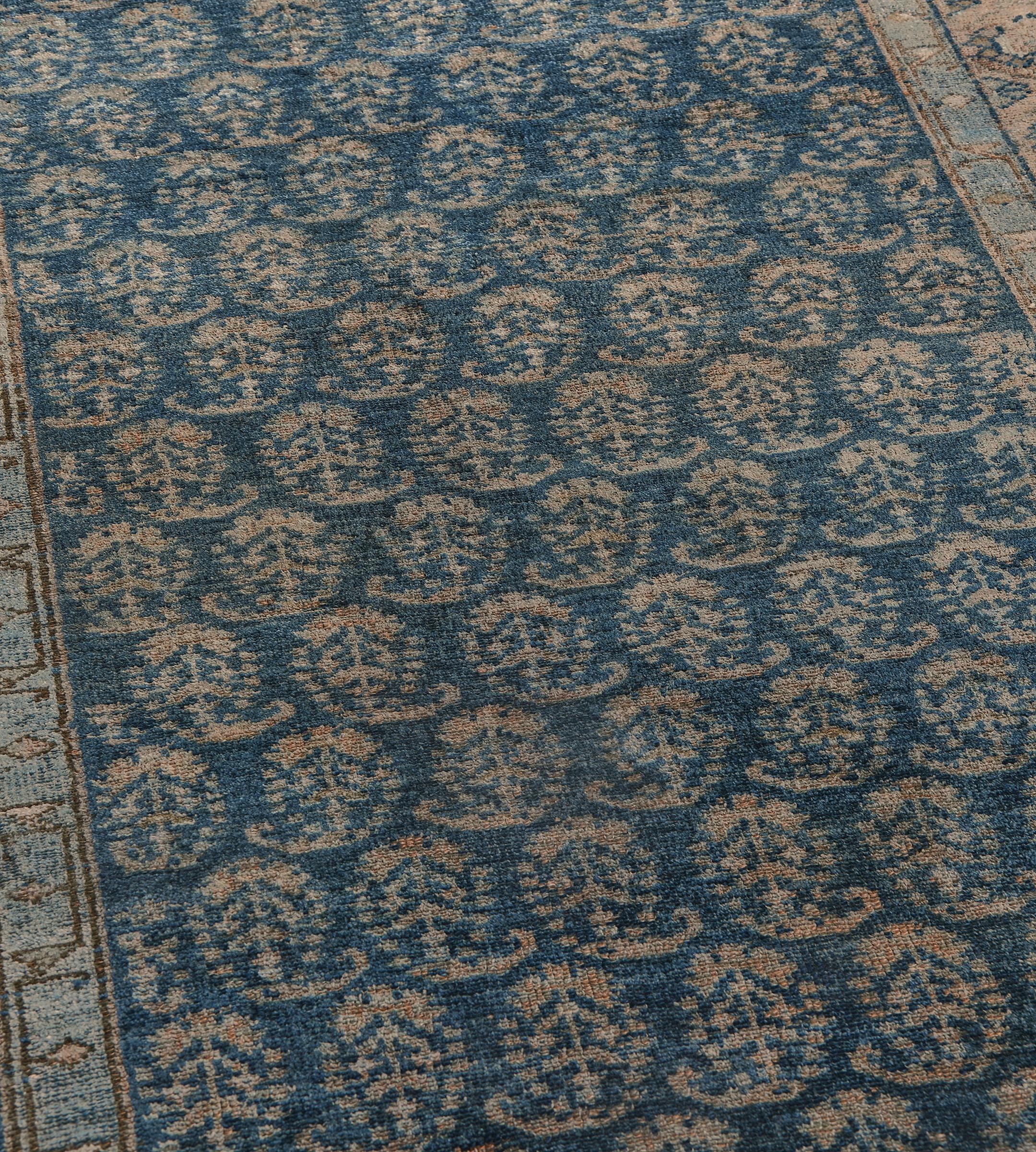 Questo antico runner persiano Serab ha un campo blu indaco sfumato con un disegno complessivo di file orizzontali di boteh in terracotta chiara, alternativamente rivolti verso l'alto, in un bordo in terracotta con motivi floreali collegati,