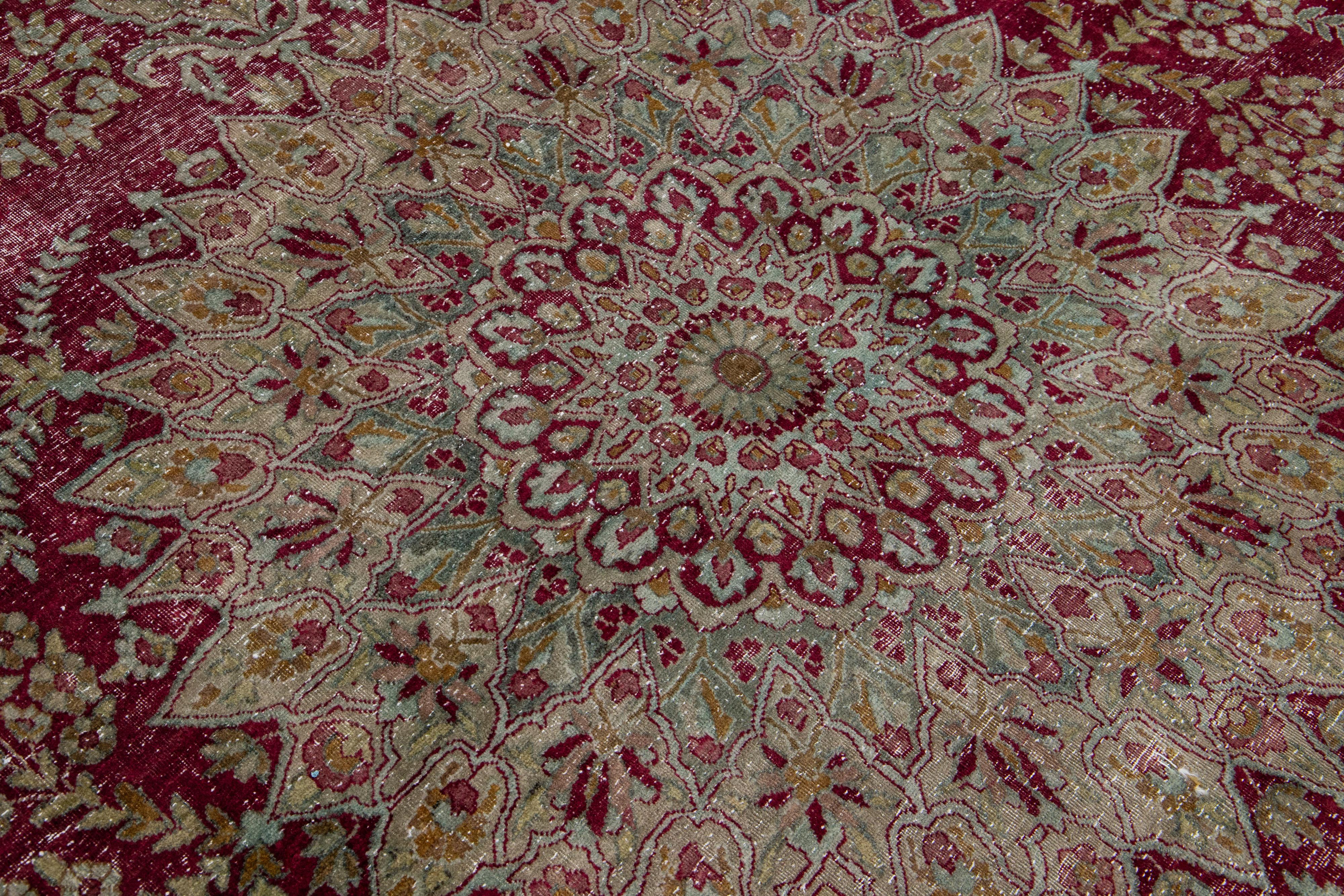 Noué à la main Tapis persan Kerman ancien présentant un motif floral en médaillon en vente