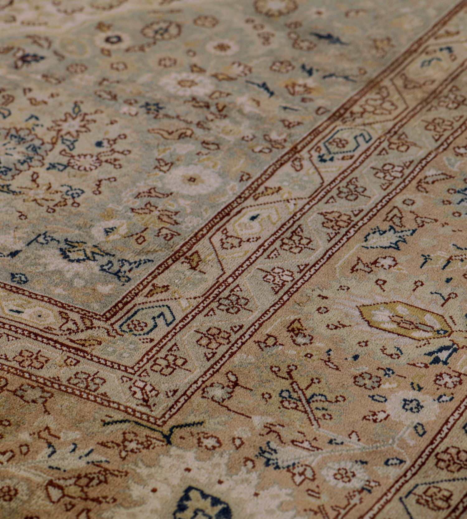 This traditional handwoven Turkish Sivas rug has a muted beige mil-fleur field, with complementary sage-gray spandrels, each enclosing delicate roundels, in a muted fox-brown linked palmette border, between complementary ornage vine