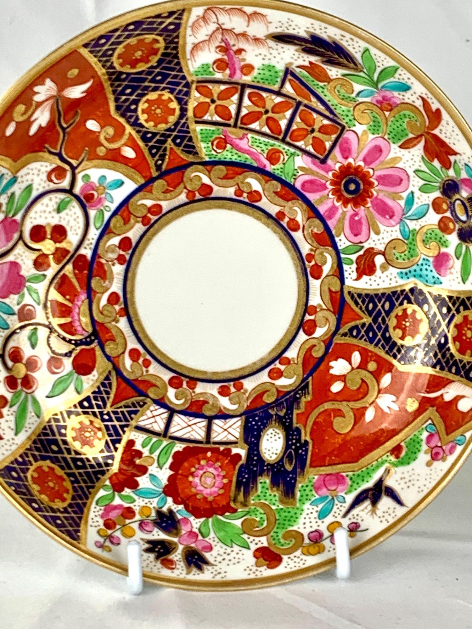 Diese antike Frühstückstasse mit Untertasse wurde von Barr Flight Barr in der Fabrik in Worcester, England, um 1810 handbemalt.
Die Dekoration ist üppig und weist schöne Details auf: große stilisierte Blumen, Gartenzäune, Felsen und einen fliegenden