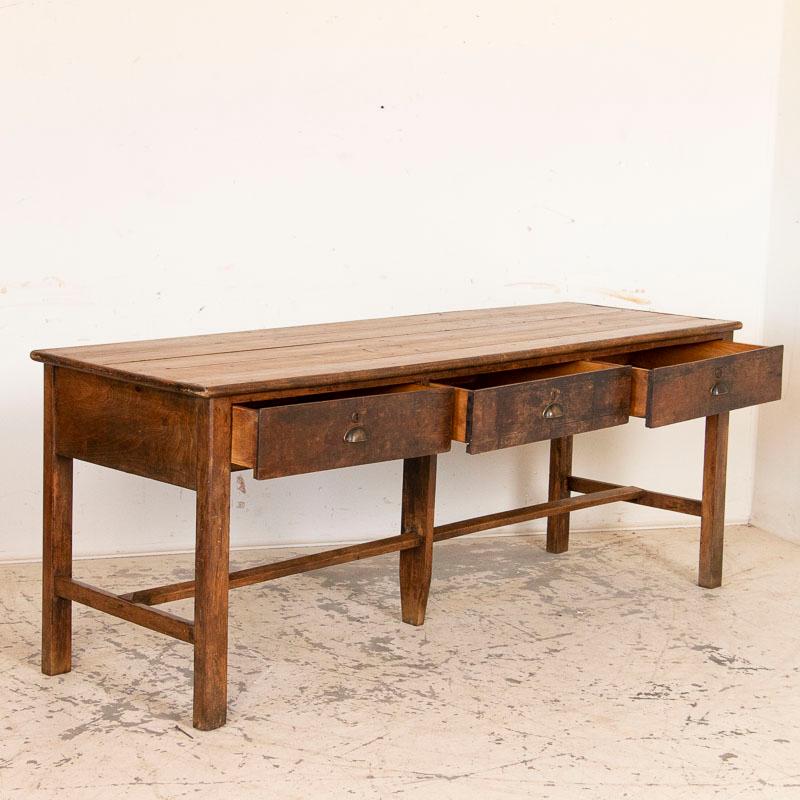 Just look at the natural, deep patina of this large work table or long counter from the mid-1800s and one is instantly 