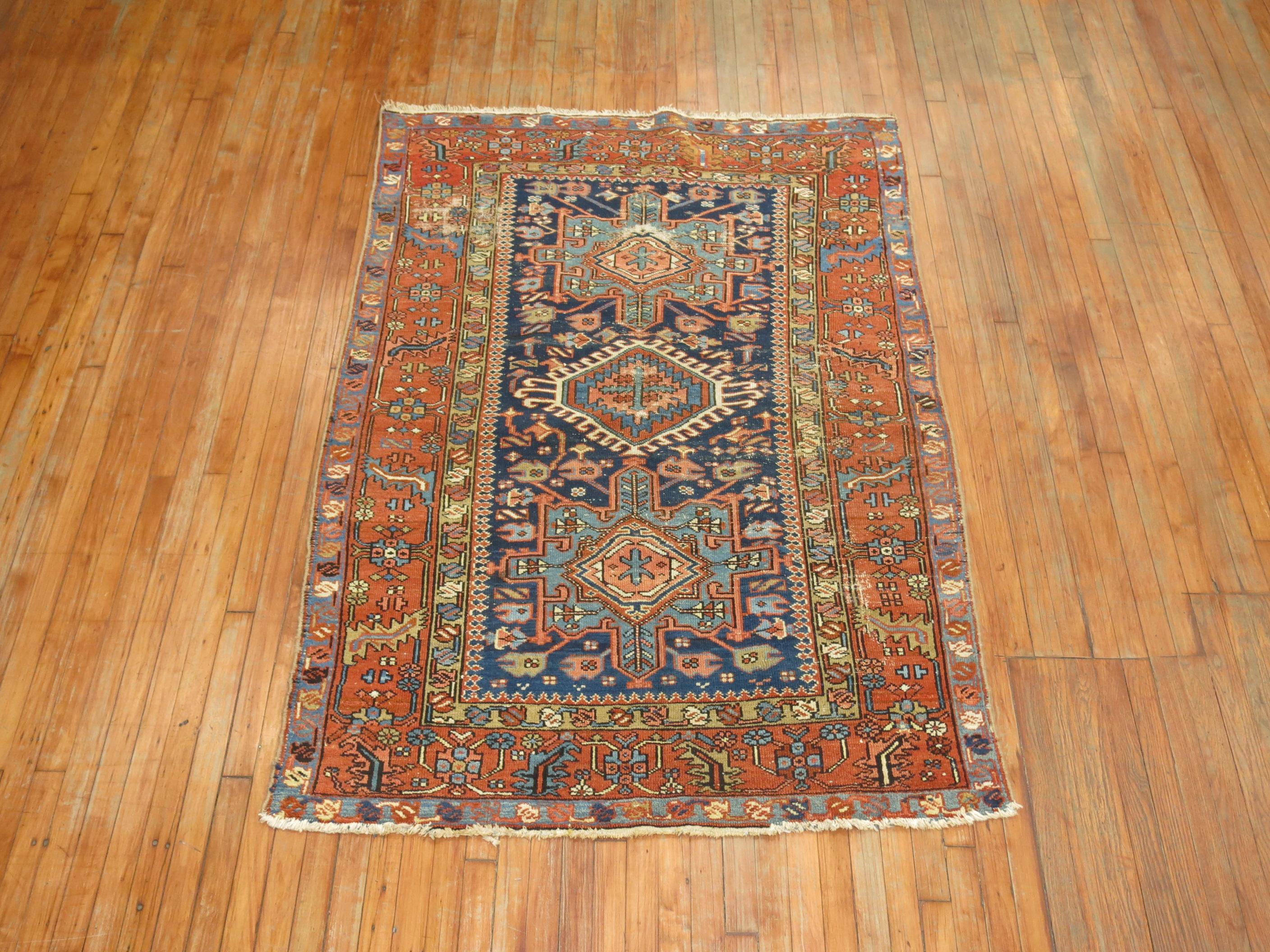Antique Persian Heriz rug with an all-over geometric motif on a medium blue ground.