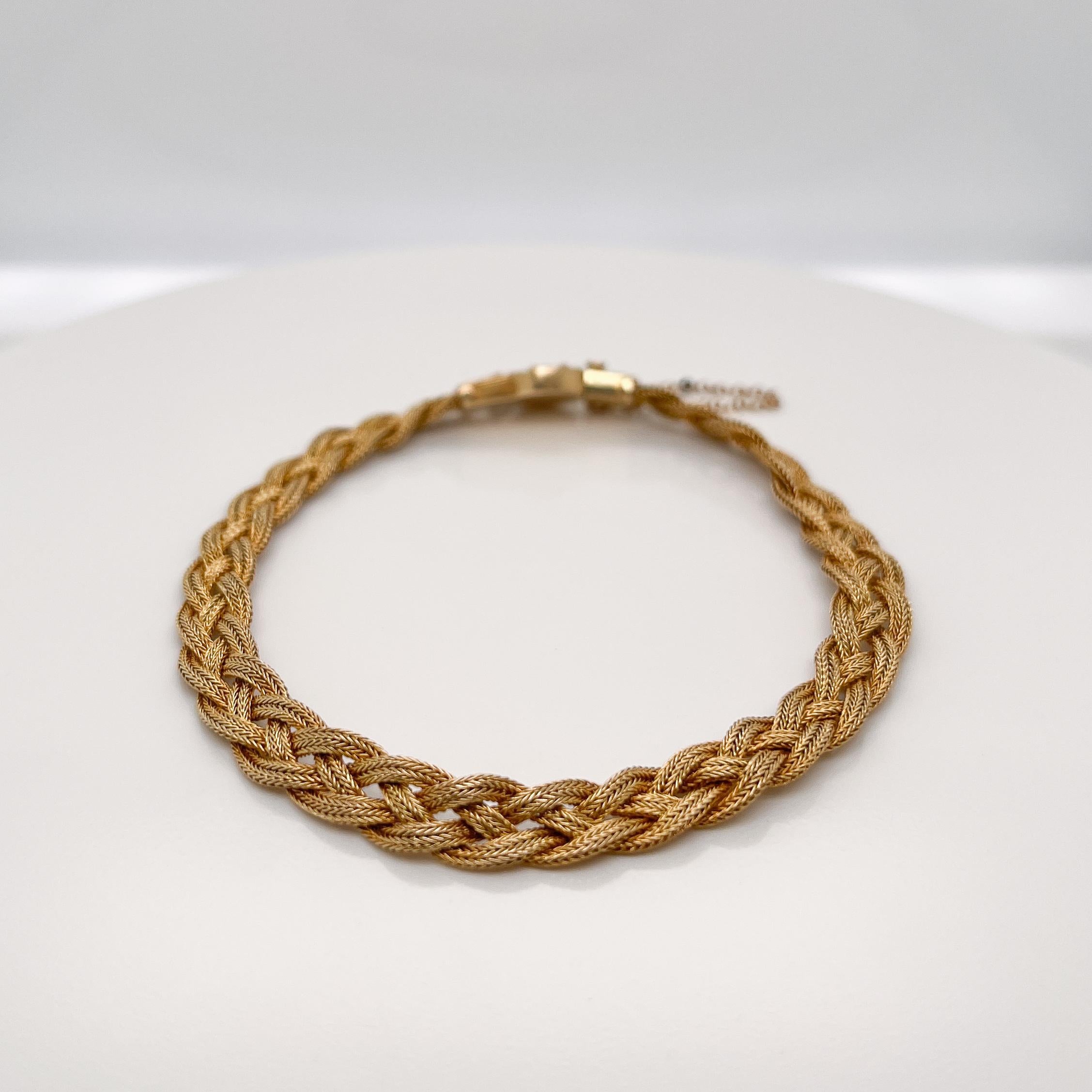 A very fine 14k gold Etruscan style bracelet.

With three delicate strands of woven braided gold wire terminating in an Etruscan style box clasp with granulated and wire work decoration. 

Set with a safety chain.

Simply a finely-made Etruscan