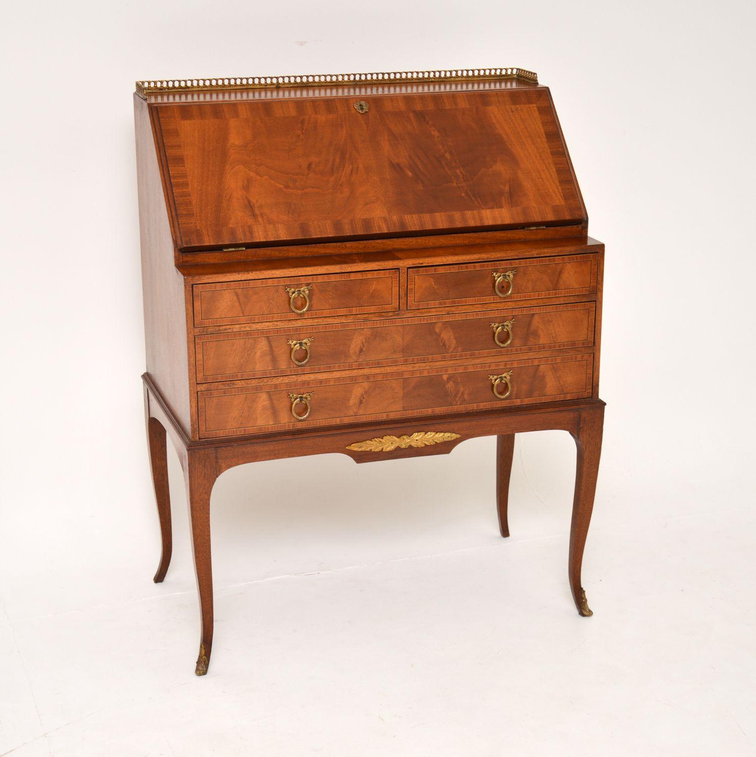 An elegant neo-classical style antique writing bureau in wood with gilt bronze mounts, dating from around the 1920’s period.

The quality is outstanding, with gorgeous flame wood grain patterns and an inset leather writing surface. The brass