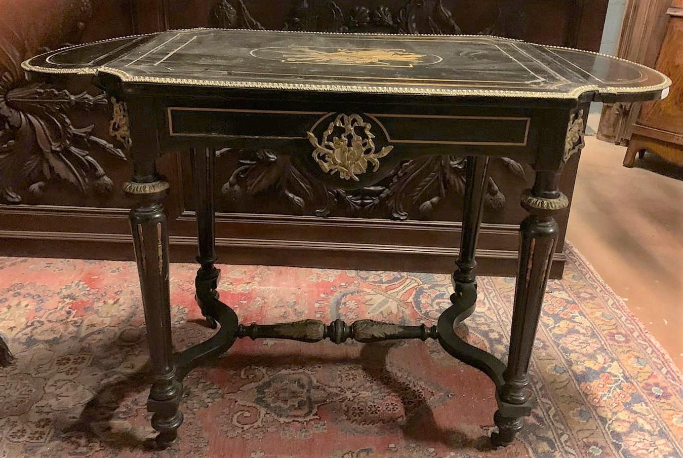 Antique writing desk in black lacquered wood, with adjustable flaps on the sides, rich ornaments in gilded brass, built according to the fashion of the late 19th century in France. The side shelves measuring 20 cm w each, can be raised if necessary,