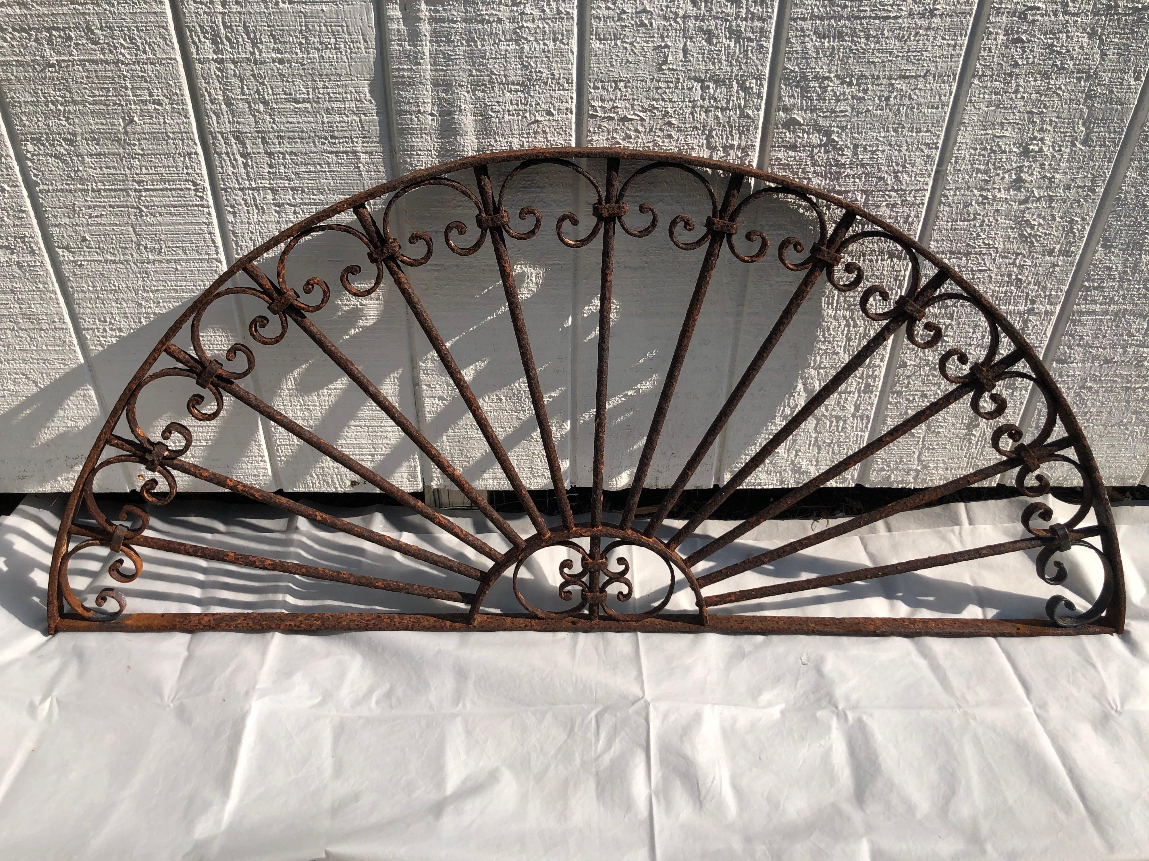 Antique wrought iron decorative Transom or window guard. Lovely half moon shape with detailed scroll work.
Some restoration done to piece. See photos. Perfect ornamentation for above a door or in a garden.
Heavy, solid piece. Some rust due to being