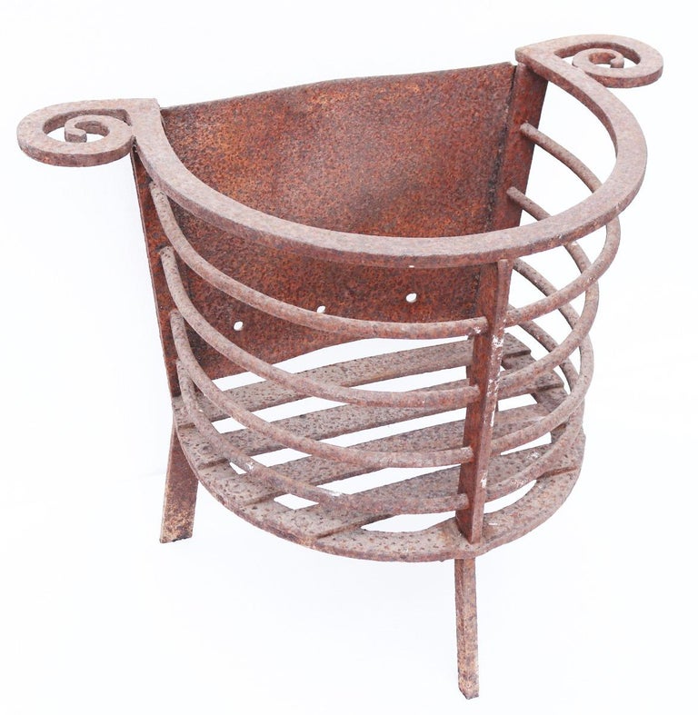 A reclaimed blacksmith made iron fire basket of rounded form.