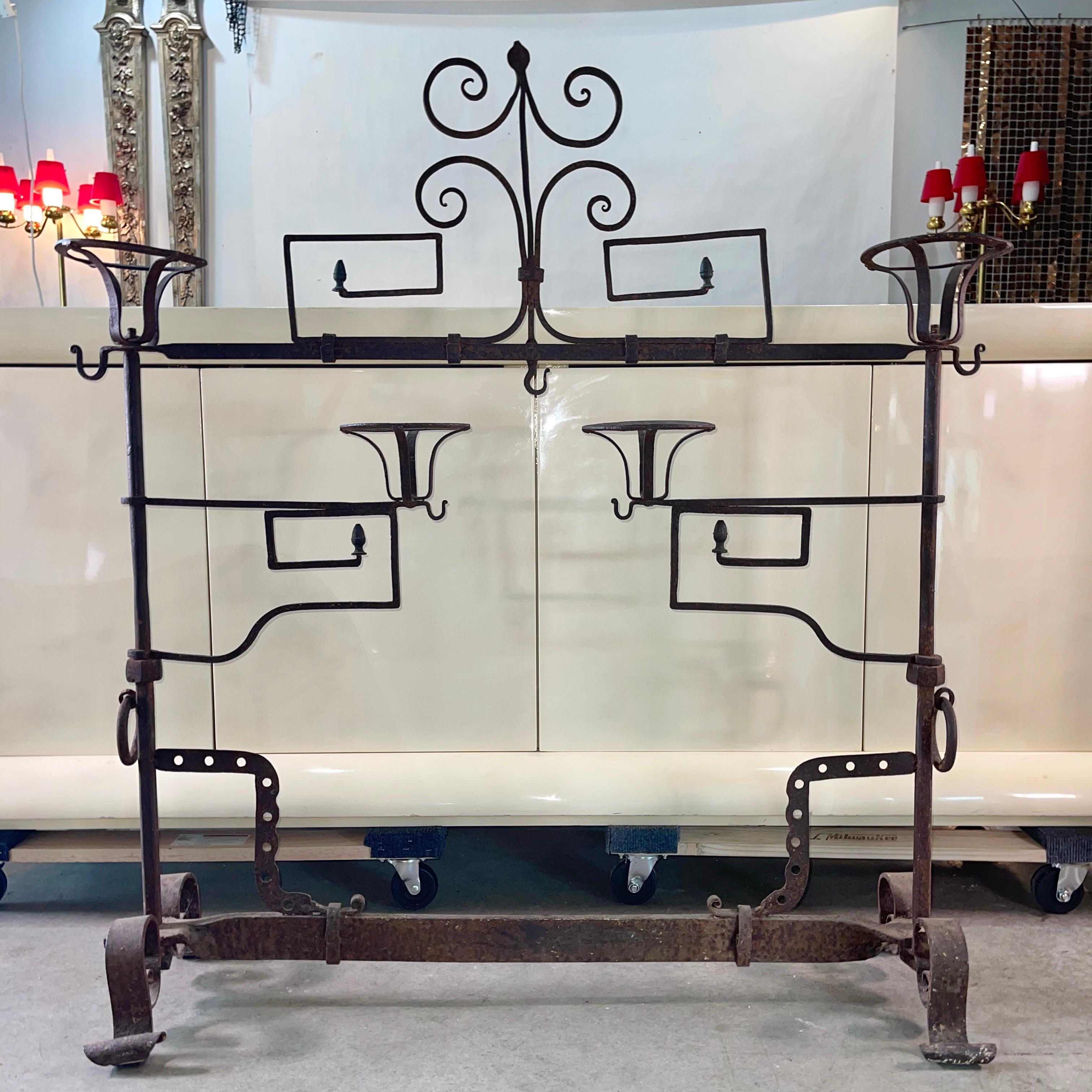 French 18th century fer forge lanier fireplace screen with two swing out arms and four baskets, leafy scroll decoration, rings and hooks for hanging utensils, standing on scrolled feet.

Reference: Les objets de la vie domestique: Ustensiles en