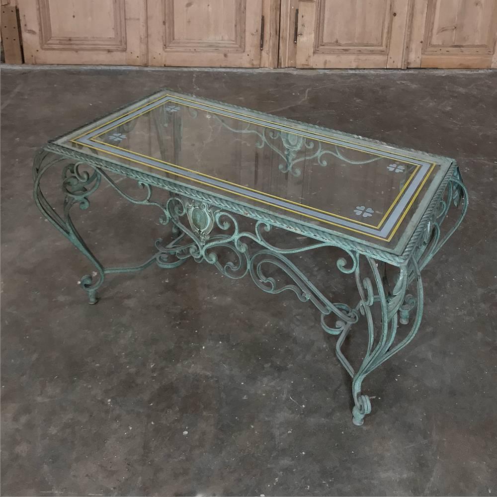Antique wrought iron glass top coffee table features a patinated painted finish and classic Venetian flair in the scrollwork on the frame. Glass top ensures carefree enjoyment, and has been etched with a border all around and four leaf clovers on