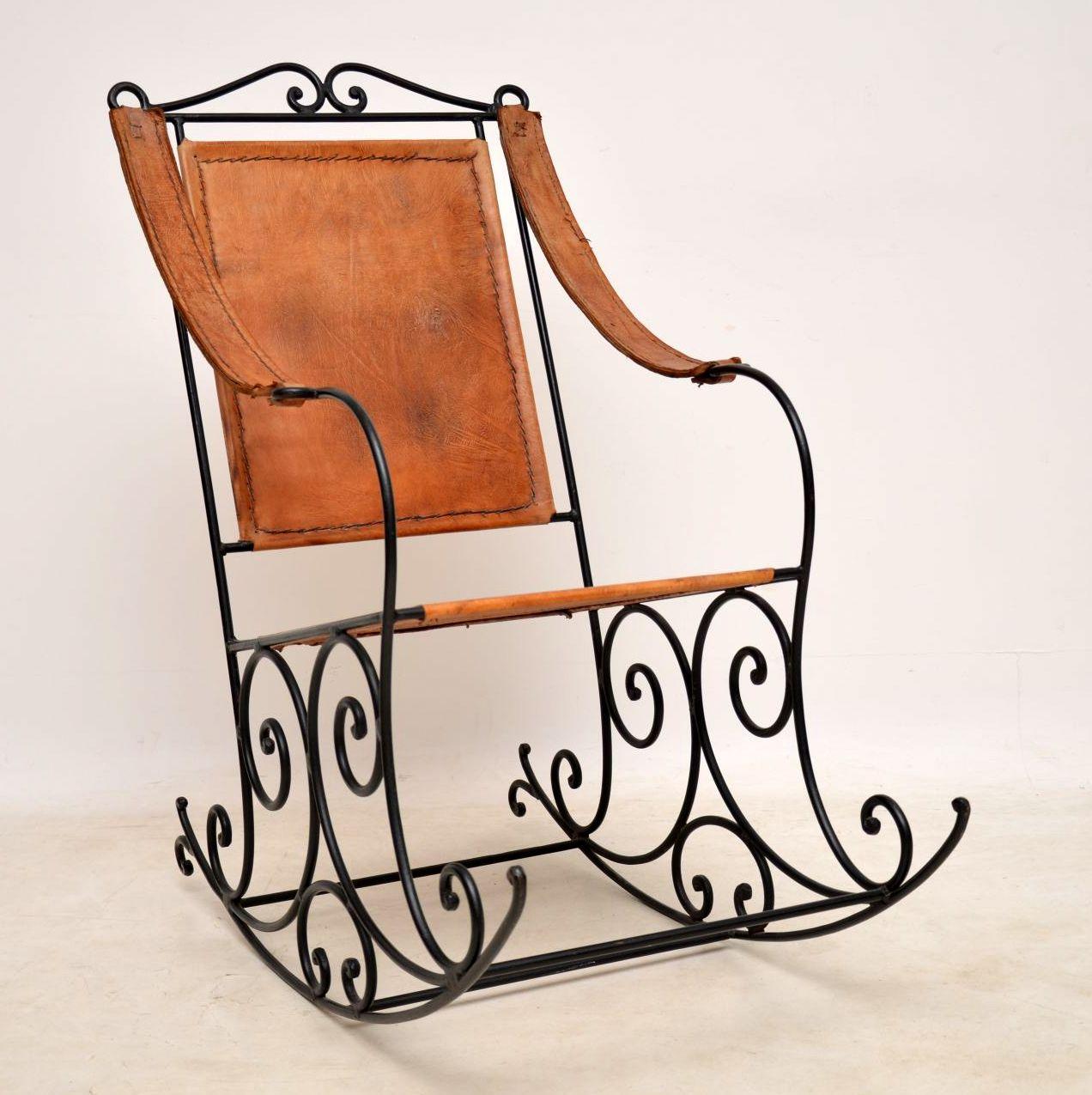 Very quirky wrought iron rocking chair upholstered in distressed brown leather. The wrought iron frame has a beautiful design and the distressed leather complements it very well. The leather itself is in good condition and is naturally aged. It