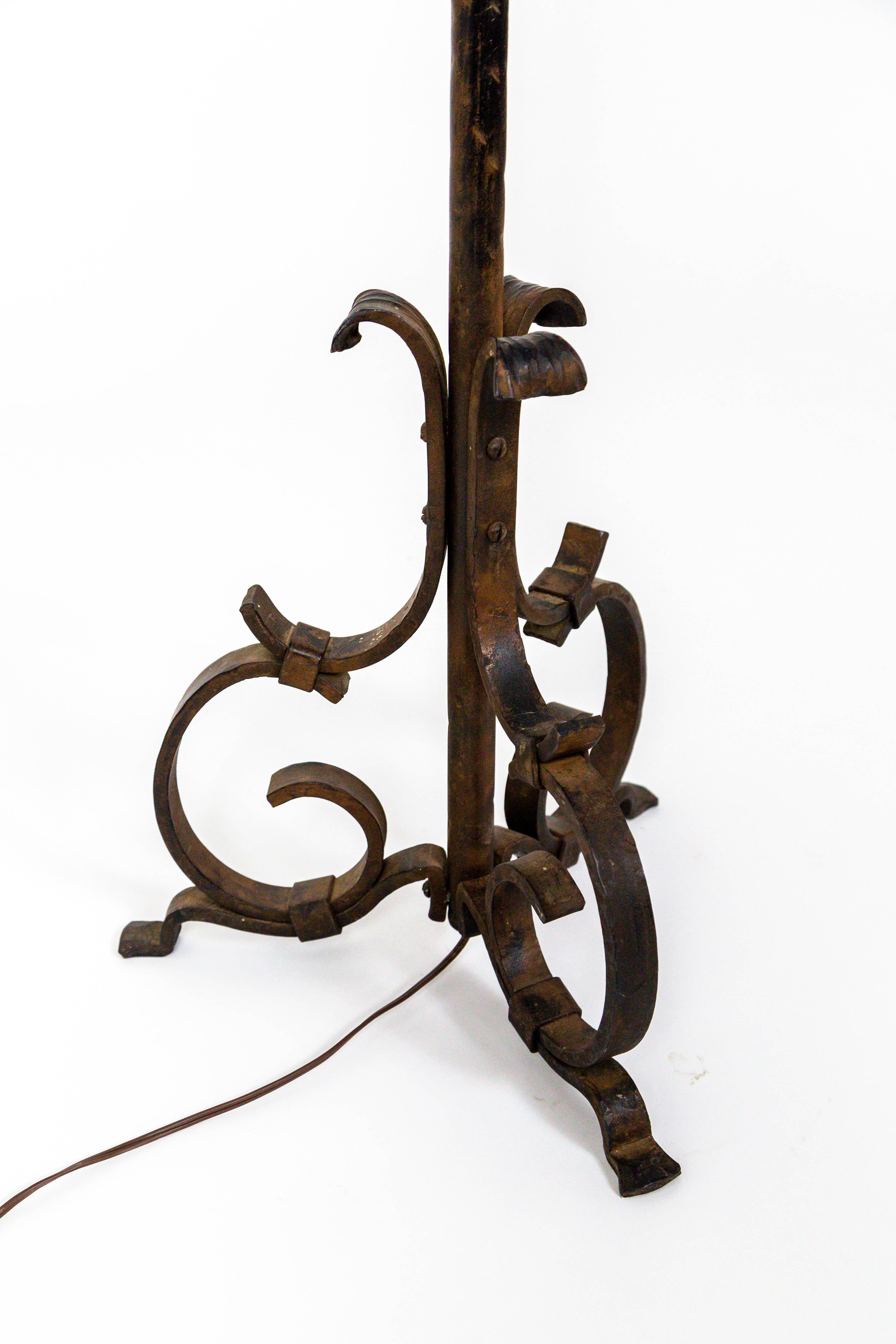 A beautiful, French, handwrought iron floor lamp with Renaissance Revival influences; textural, hammered accents, and leaf details on the stem, circa late 1930s. Measures: 67.75