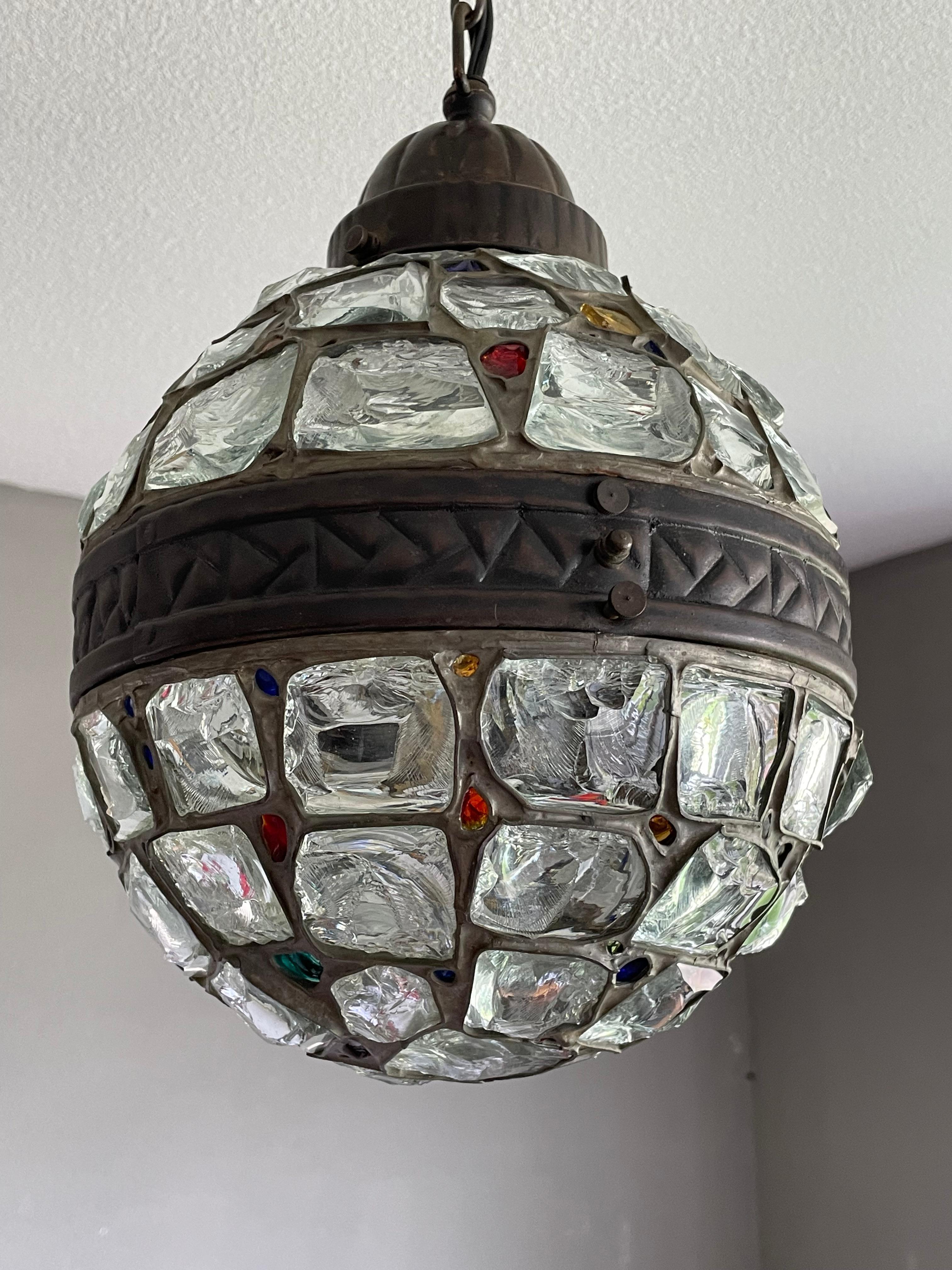 Very cool, metal and inlaid 'chunky glass' light fixture from the early 1900s.

This great looking and artistic workmanship pendant from the earliest years of the 20th century is another one of our recent great finds. With early 20th century