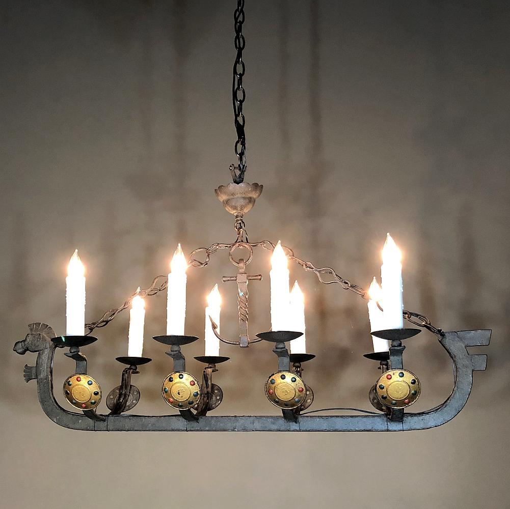 Antique wrought Iron Viking chandelier represents the infamous longboat that was surprisingly seaworthy when manned by the able mariners of Scandinavia. Fearsome beasts were carved into the foresprit for intimidation factor, and shields were placed