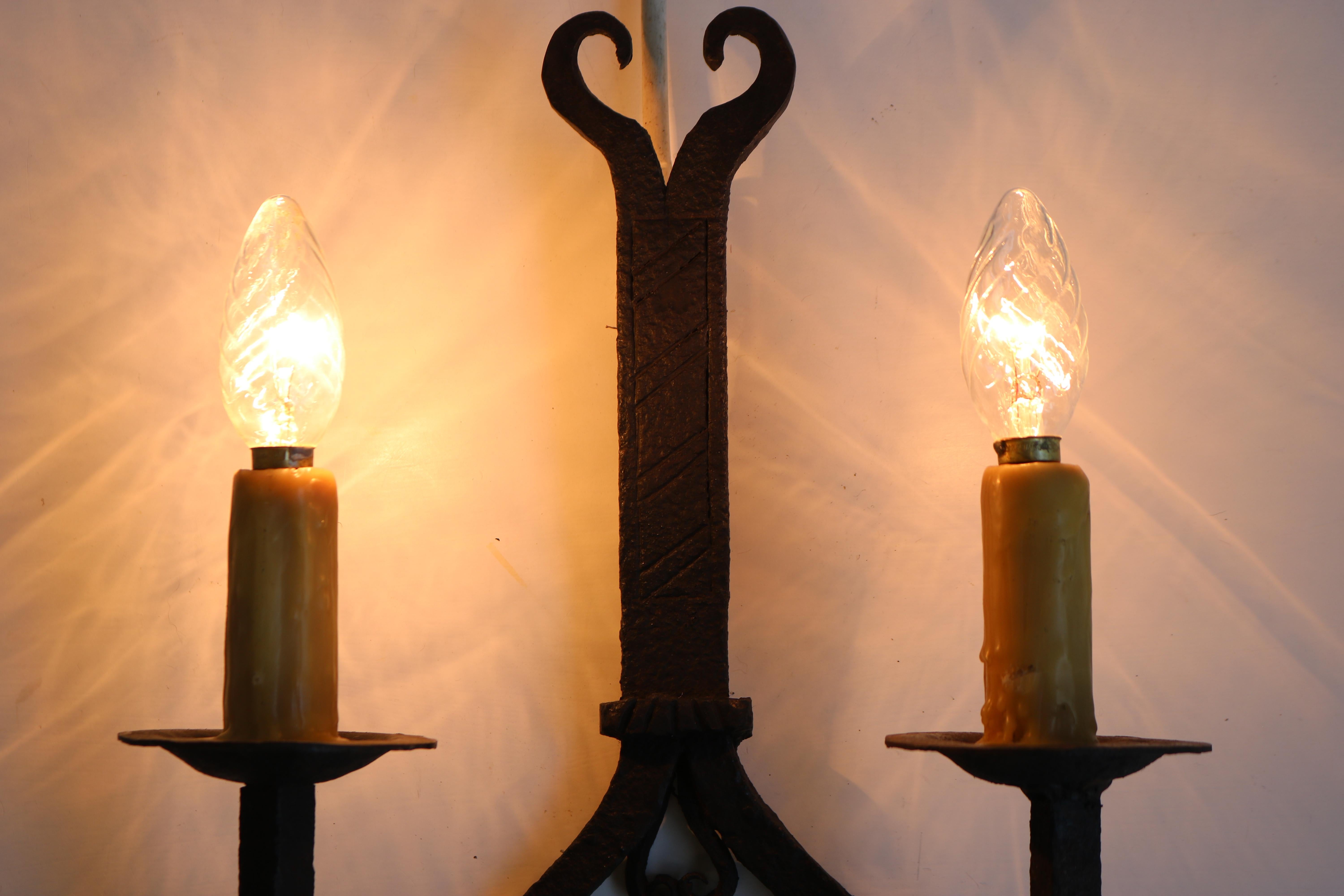 Lovely pair of hand-crafted wrought iron wall lights from France 1900. Gothic revival style or Arts & crafts. 
They are heavy and fully hand made, really gorgeous details. 
Fully original with gorgeous candle wax covered light sockets. 

One of