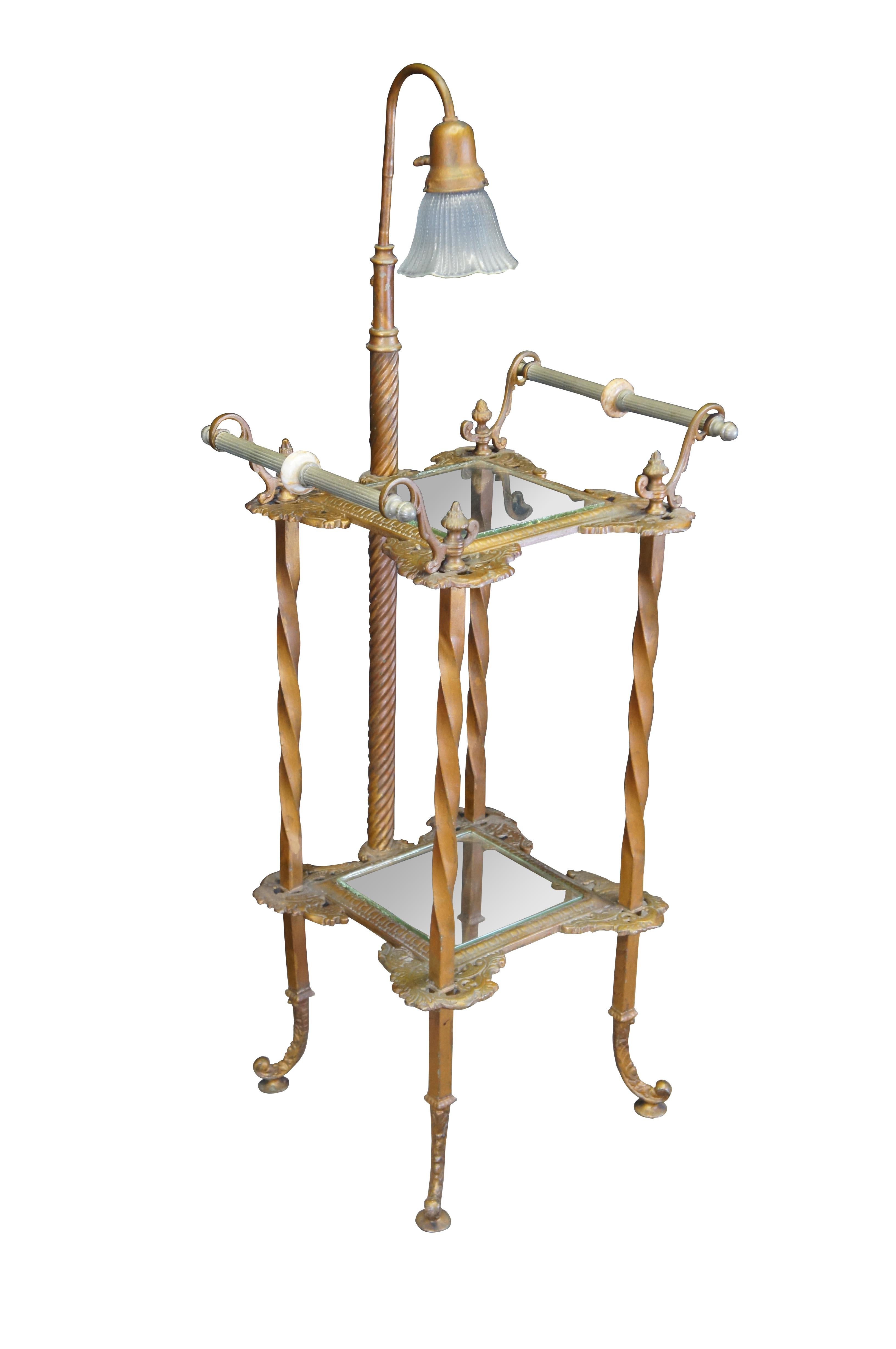 Antique Art Nouveau style parlor floor lamp / telephone / plant stand / side table featuring a two tier design with barley twisted columns supporting a Tiffany style lamp that illuminates through the two glass shelves.  Ornate handles adorn the