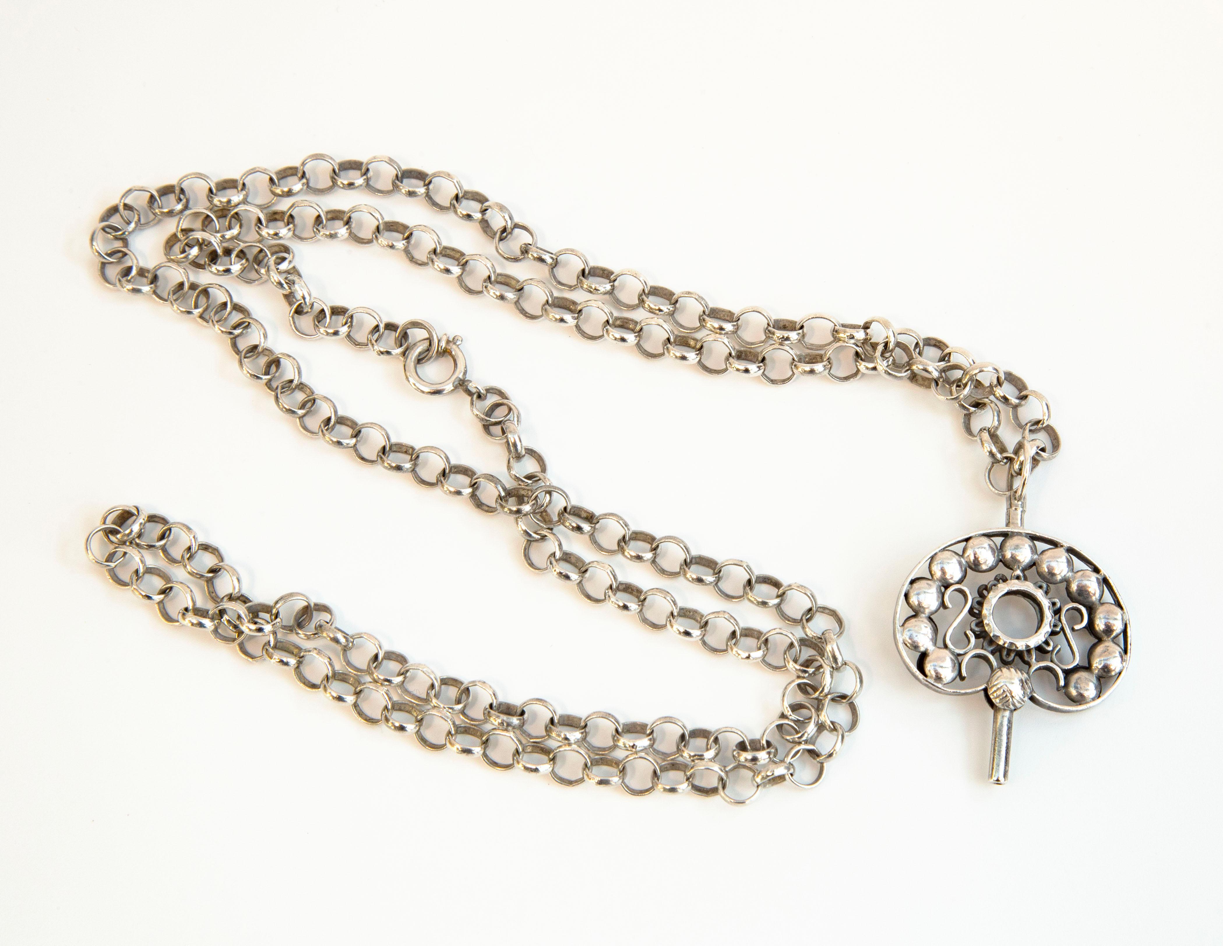 An antique silver jasseron necklace with an antique watch key (pendant). The necklace can be closed with a spring ring clasp that is in good working condition.  The items were manufactured in the Netherlands in the first half of the 19th century,